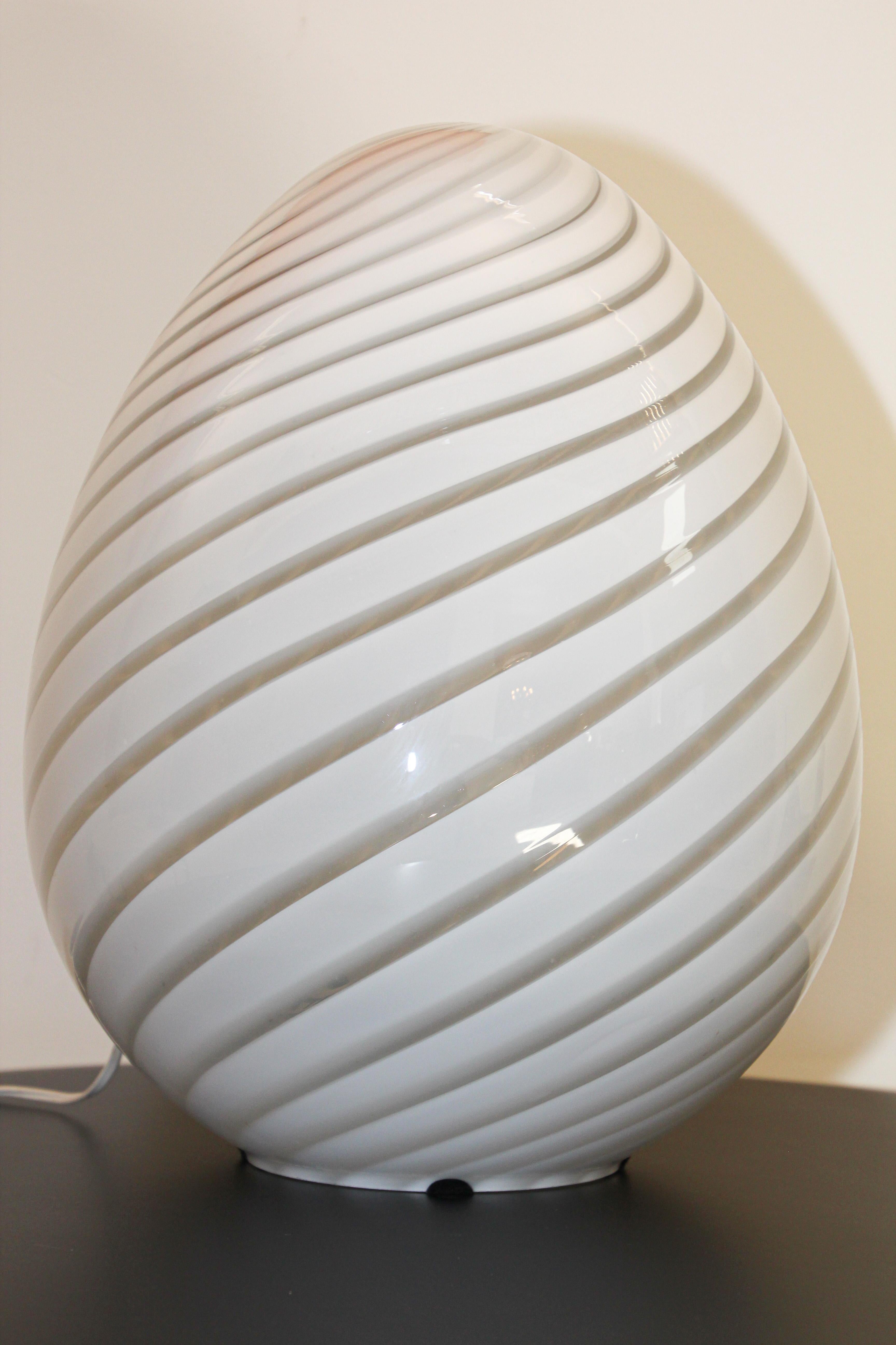 Stunning large swirled glass lamp by Vetri murano egg lamp.
Amazing large scale Modern Egg-shaped white Murano glass table lamp light by Fulvio Bianconi for Venini in the sensual shape of an egg having the classic swirl pattern lines in the glass.