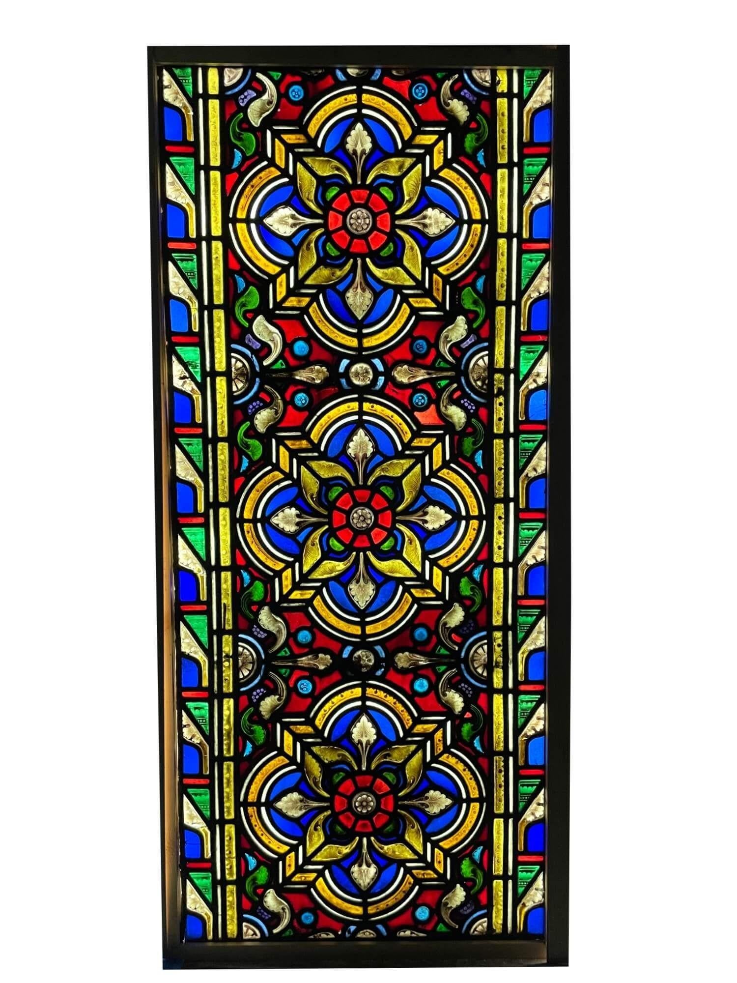 An antique Victorian late 19th century stained glass window, originally from a church in northern England. Three hand painted detailed flowers, thought to be Tudor Rose, sit at the heart of this piece. It incorporates both ecclesiastical and