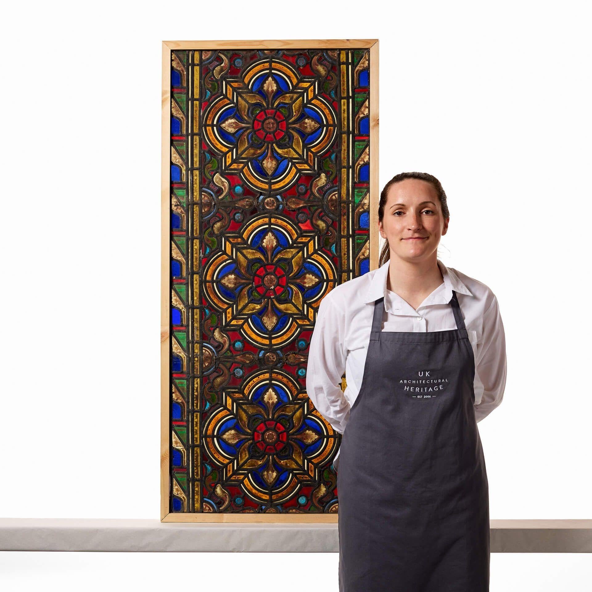An antique Victorian late 19th century stained glass window, originally from a church in northern England. Three hand painted detailed flowers, thought to be Tudor Rose, sit at the heart of this piece. It incorporates both ecclesiastical and