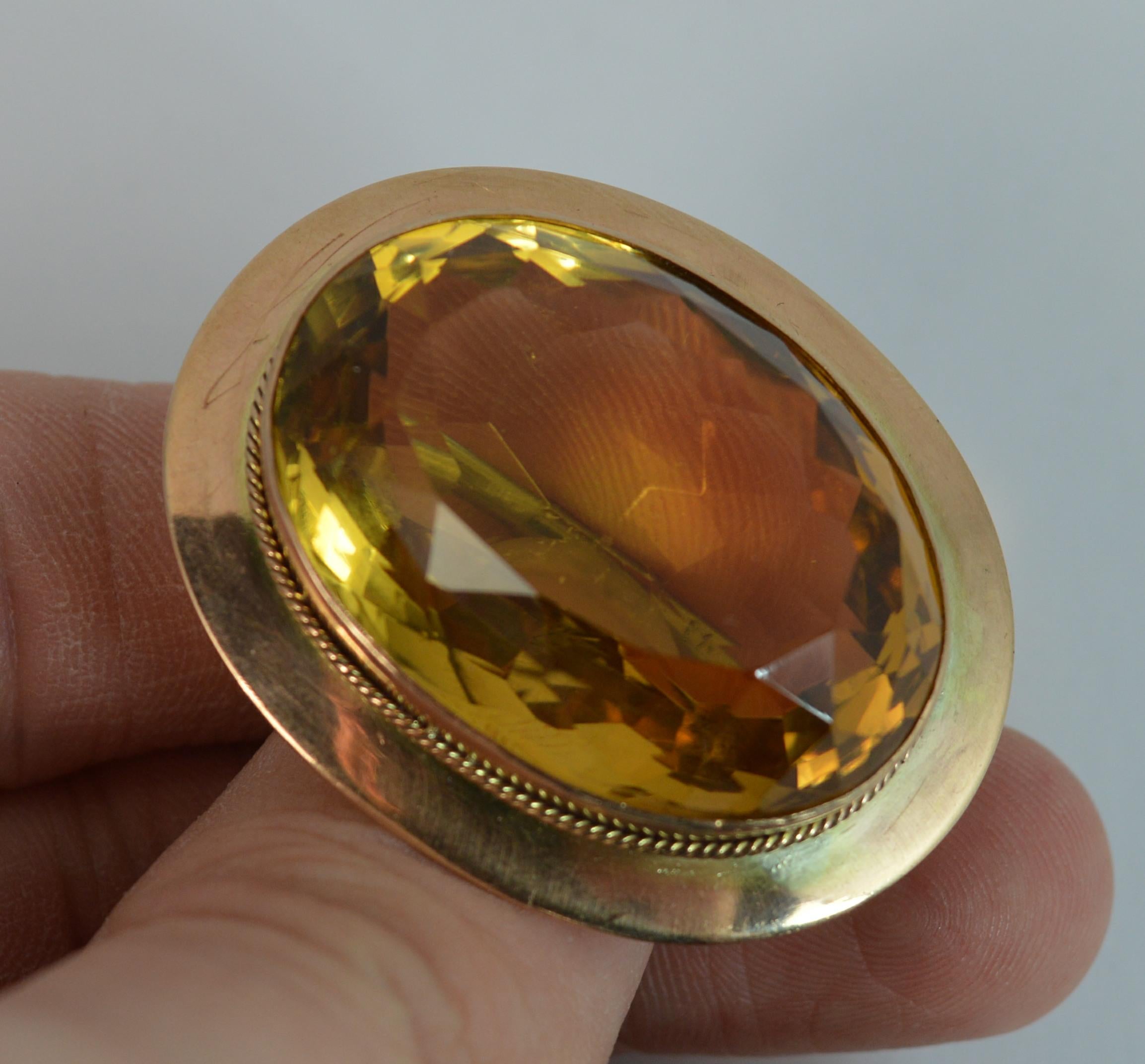 A stunning Citrine and 9ct Gold statement piece.
Large oval cut natural citrine, 23mm x 30mm approx, 48 carats.
Surrounded by a plain 9 carat rose gold border.

CONDITION ; Very good for age. Crisp design. Well set stone. Working pin. Issue free.