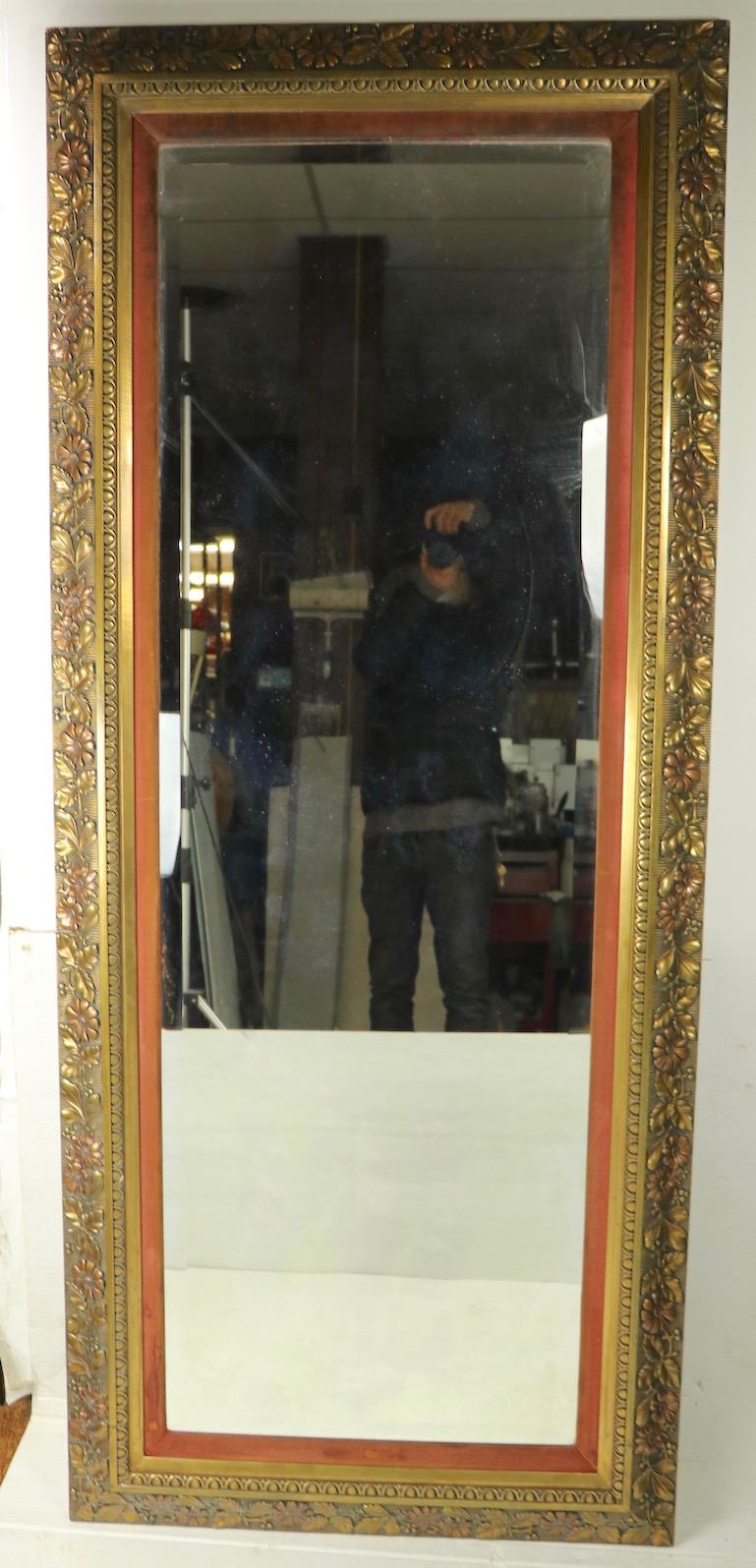 Nice large Victorian pier mirror having a substantial carved wood frame with velvet interior boarder (shows wear) and beveled plate glass mirror. The frame features dimensional foliate design, reminiscent of the later Arts & Crafts Movement.