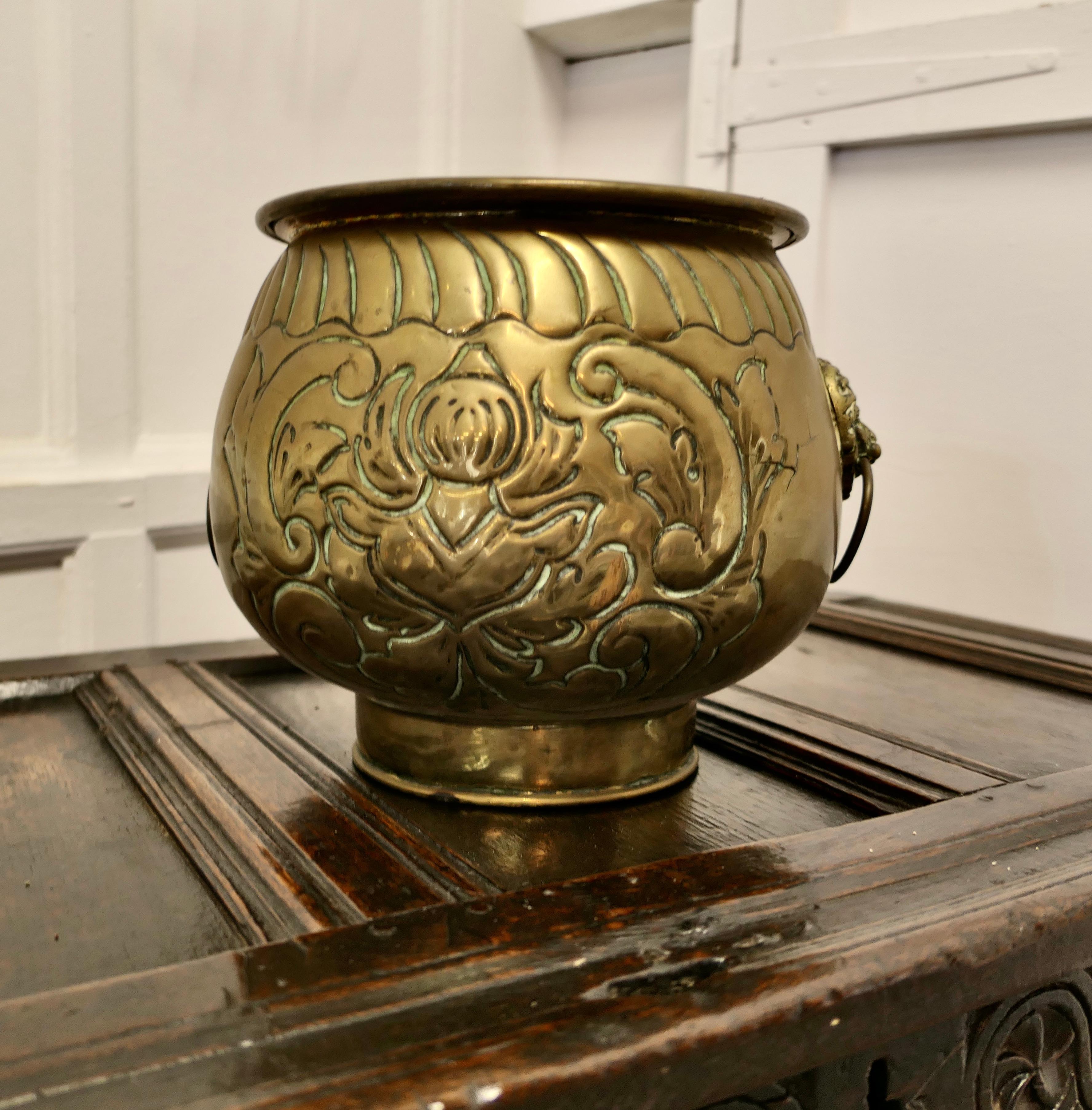 Large Victorian Brass Jardinière, Lions Mask Planter

This a good quality piece of solid brass craftsmanship, the Jardinière has a rolled top edge and lions mask ring handles
There is a decorative Coat of Arms  on the front of the container