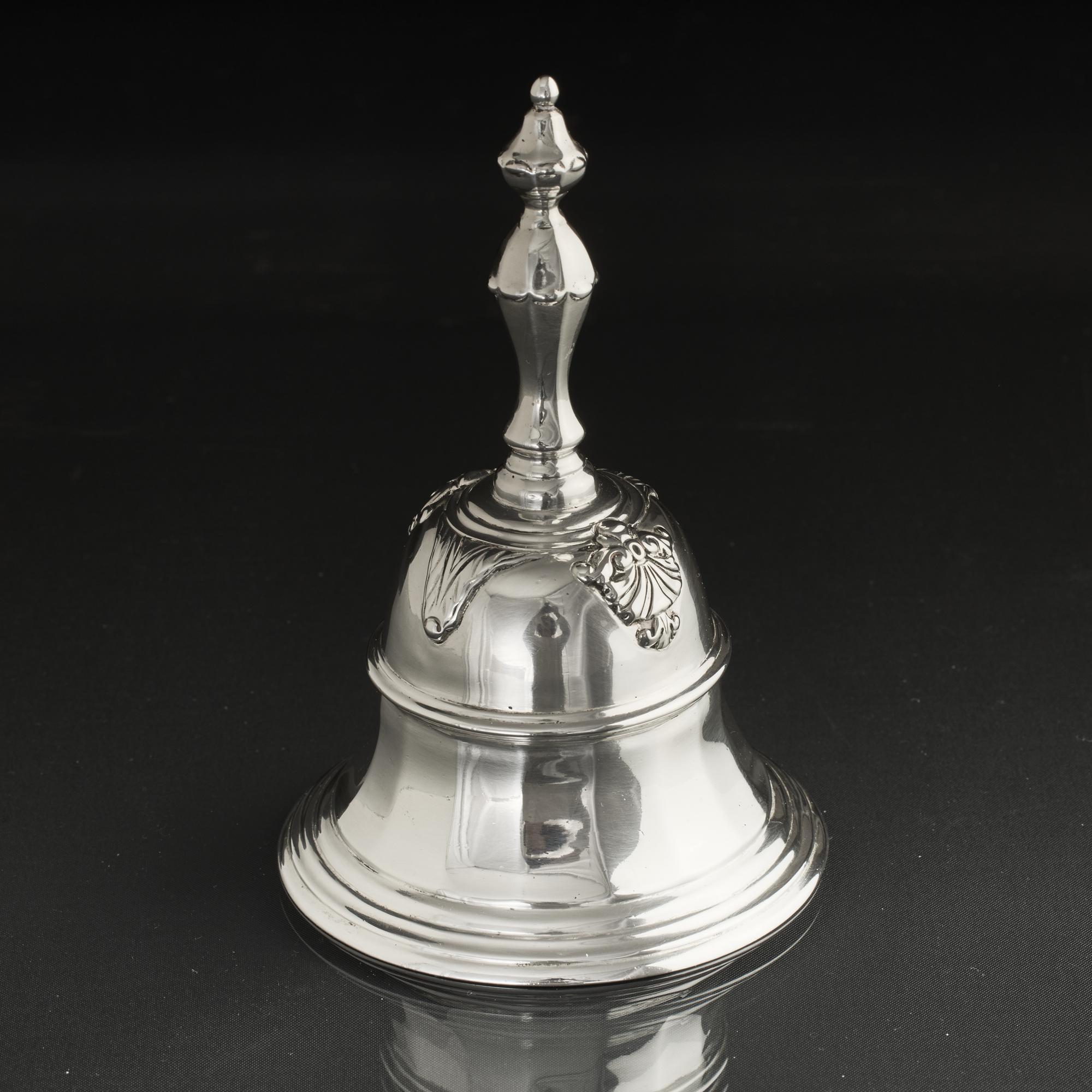 Wonderfully heavy antique silver table bell in the Georgian style with flared panelled body and applied traditional husk and acanthus leaf motifs. This bell is heavily cast in sterling silver which is comfortable to hold and gives a beautiful and