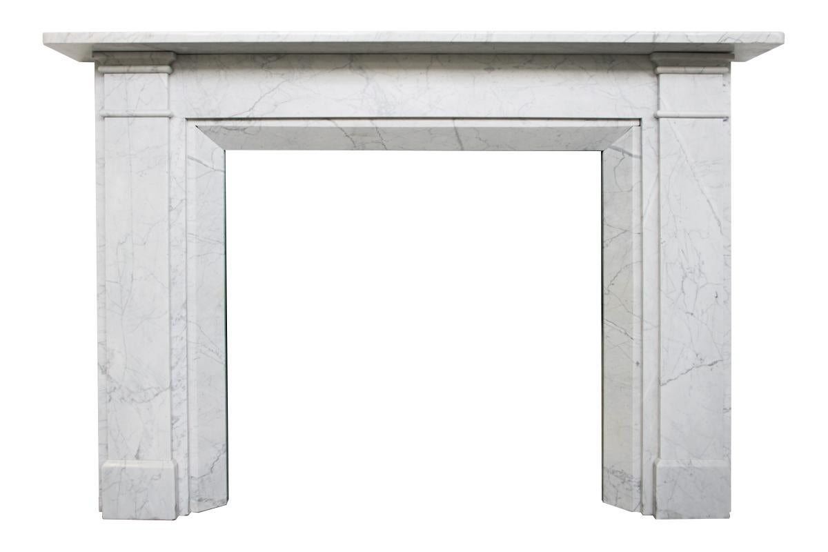 Large Victorian fireplace surround of simple form in well figured Carrara marble. Chamfered returns frame the aperture surrounded by plain jambs and frieze. English, circa 1850.

Pictured with an original cast iron grate and cast iron reducer,