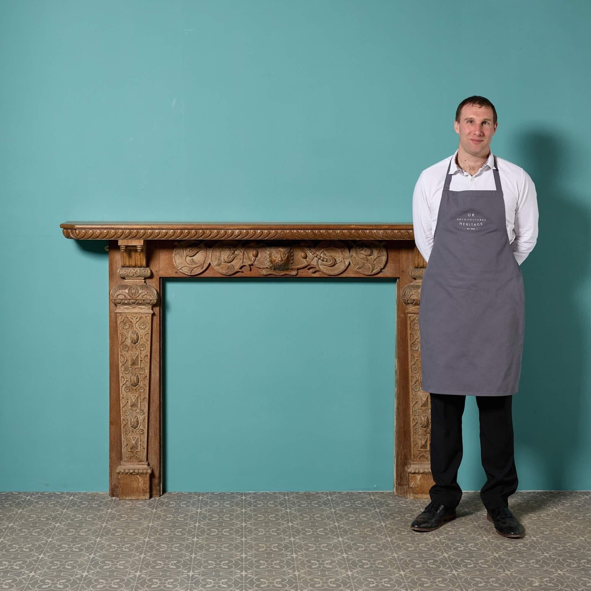 This very large scale carved oak fire mantel is a time-capsule into history. Hand-carved by a talented craftsman at the end of the 19th century, it features a decorative frieze and jambs with an ornate central mask of the Green Man, a legendary