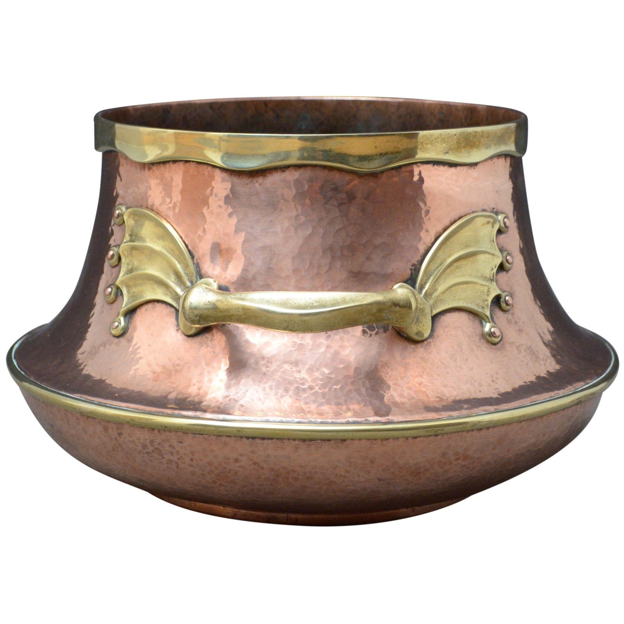 Eccezionale vaso in rame e ottone del XIX secolo di grandi proporzioni, con collare in ottone e manici in ottone con motivi di ali di pipistrello o di drago. Questo vaso antico potrebbe essere un'ottima fioriera o un secchio per l'accendino. È stato