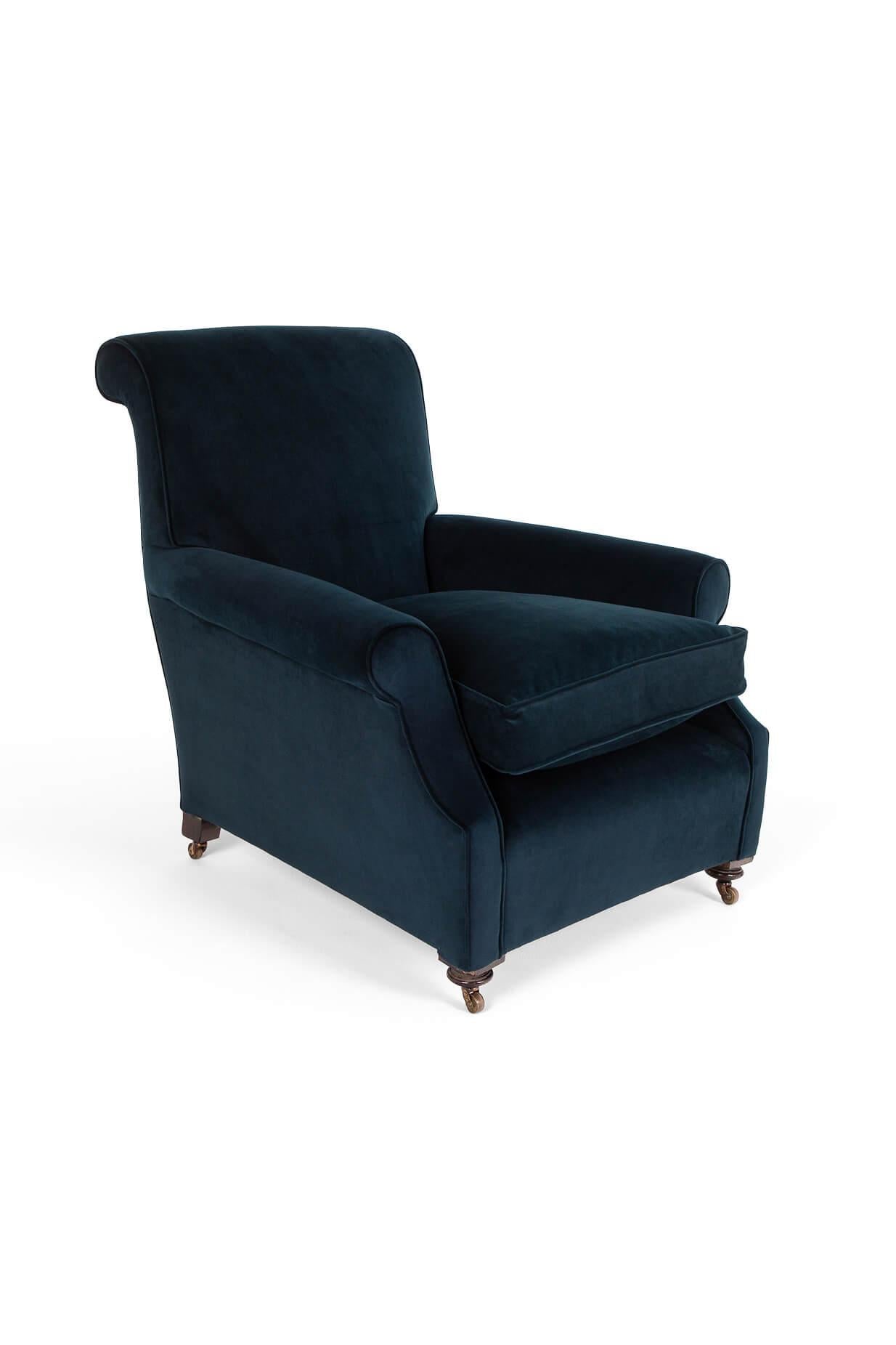 A wonderful navy blue  armchair of generous proportions.

Featuring a high back, scrolling arms and an inviting wide and deep seat.

Mahogany frame with turned front legs raised on original brass castors.

Fully reupholstered with hessian and calico