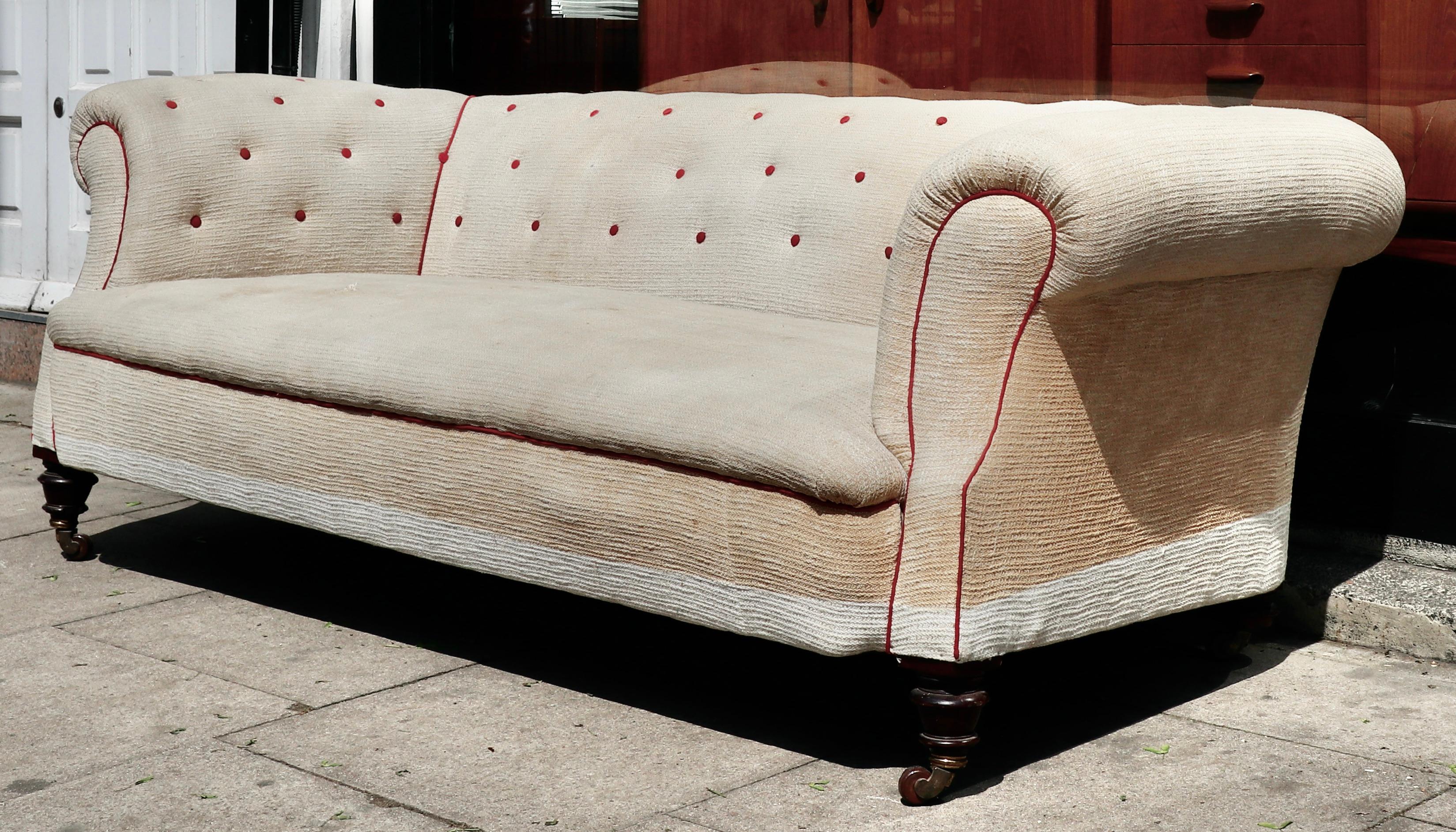 This is a superb quality large Victorian chesterfield sofa dating from around 1890.

The sofa is in need of reupholstery as the fabric is discoloured and worn. The front legs are intact but the rear ones have been cut down. The castors are original