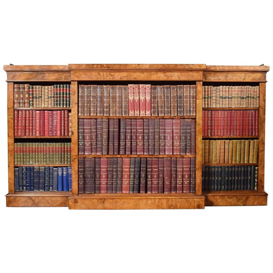 Figured walnut open bookcase, the large impressive rectangular breakfront top with raised three quarter pierced brass gallery. Above three bays of adjustable shelves each section having three shelves. All raised up on plinth