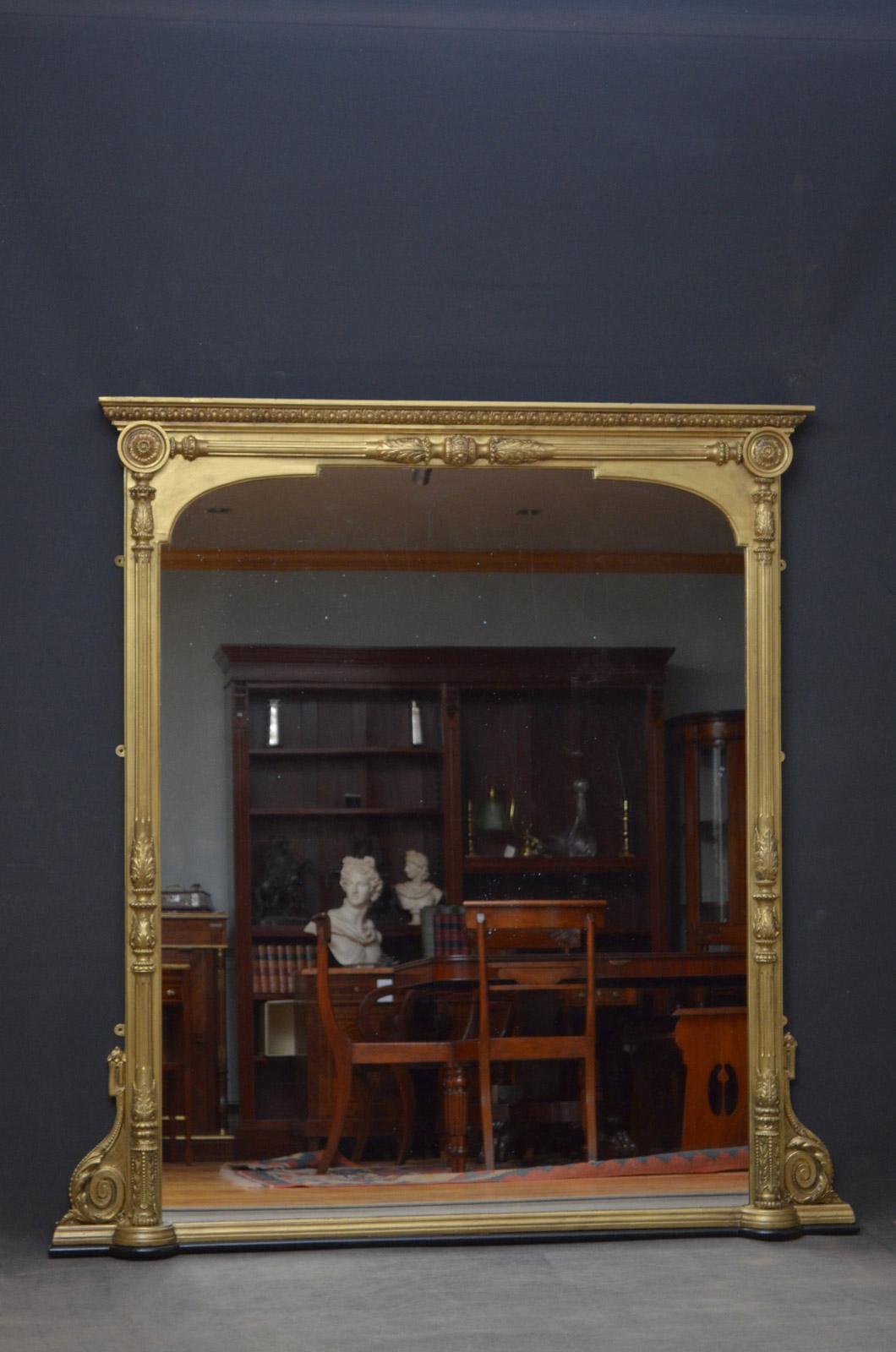 Sn4470, Victorian gilded overmantel mirror, having moulded cornice above a carved frieze and original mirror plate with some foxing in finely decorated frame flanked by half columns and scrolls to base. This antique mirror has been refinished and is