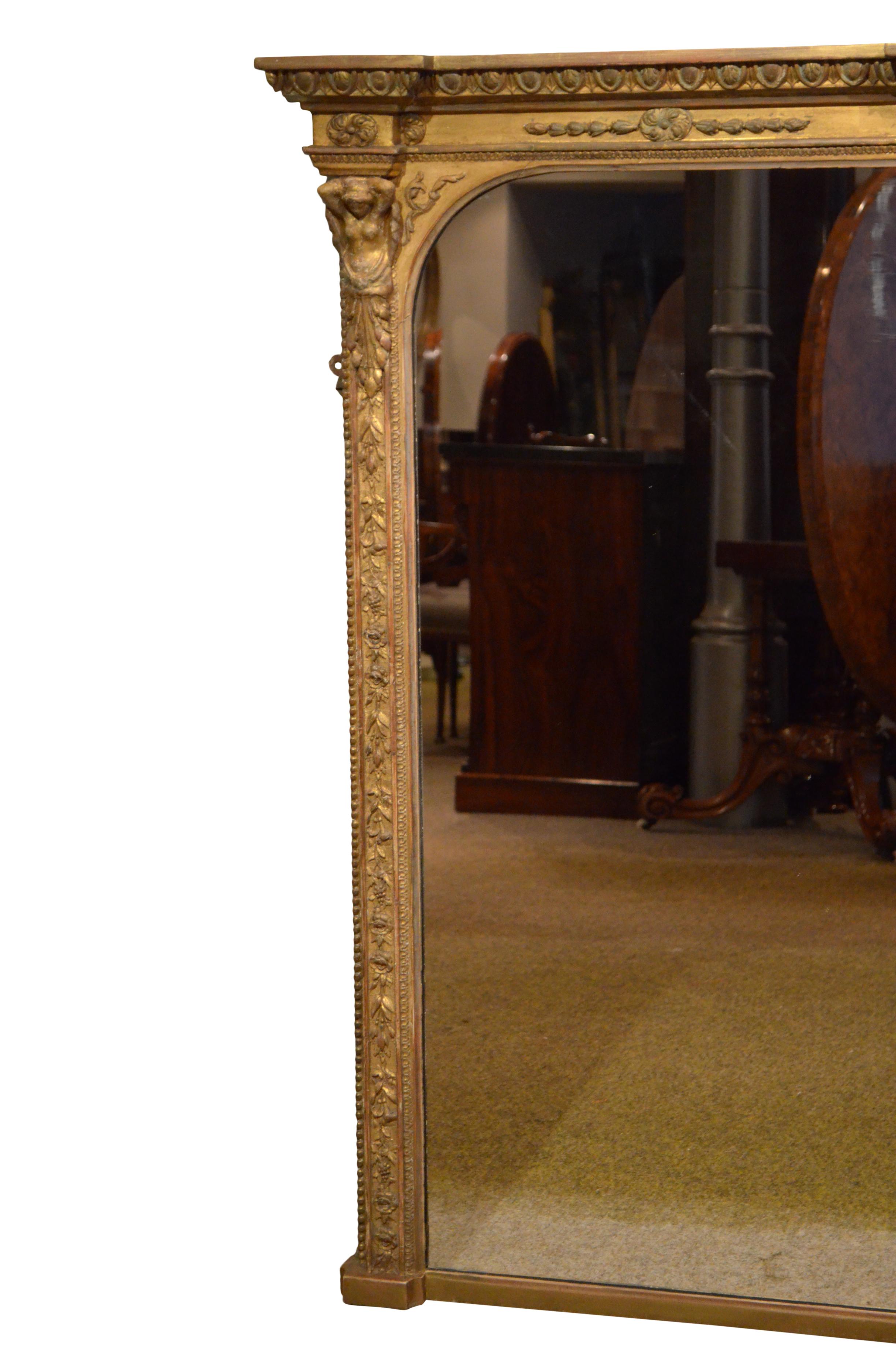 Superb English giltwood overmantel mirror, having a replacement glass in carved, beaded and floral decorated gilded frame with egg and dart carved cornice. This antique mirror retains its original finish and backboards, all in excellent home ready