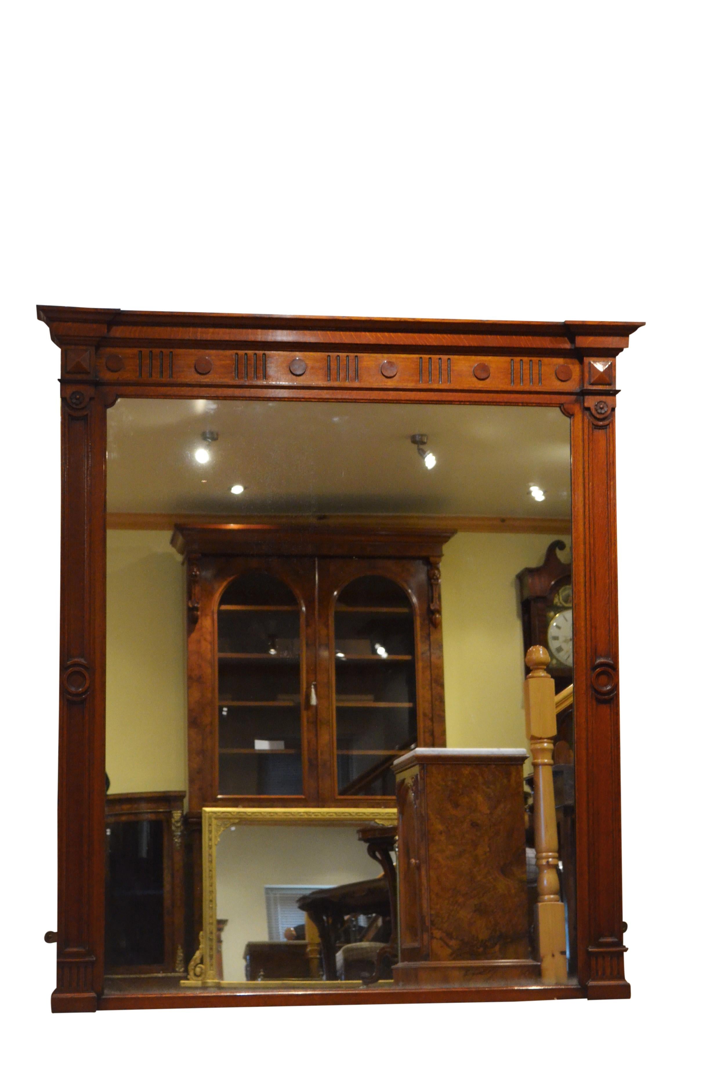 K0140 outstanding English wall mirror of large proportions, having original glass with some age related foxing, the frame having moulded cornice above reeded frieze applied with paterae and moulded pilasters with reeded capitols and flower carved