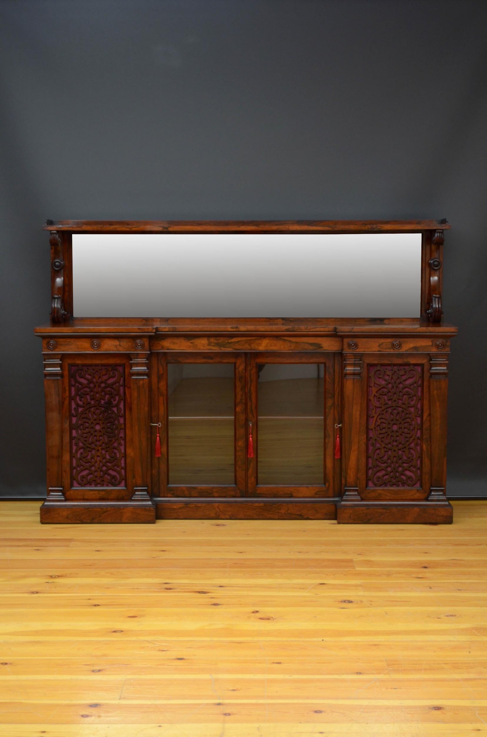 Sn4997, superb quality Early Victorian rosewood cabinet, having a superstructure with a shaped gallery, shelf and mirrored back raised on finely carved S shaped supports all above well figured top with outstanding grain and three shallow frieze