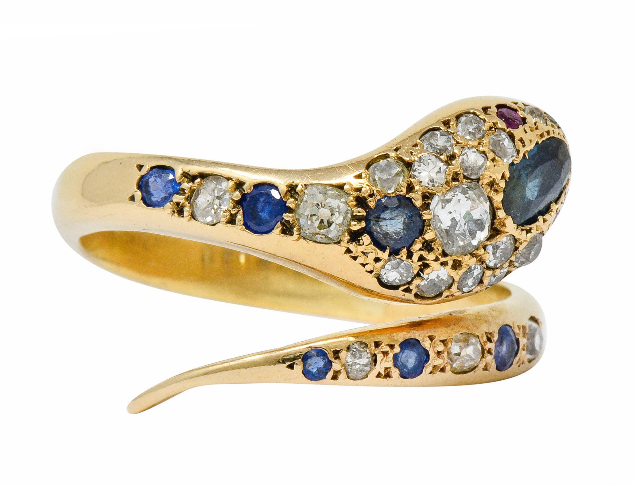 Bypass style ring designed as a coiling snake pavé set throughout by diamonds and sapphires

Sapphires are greenish-blue to royal blue in color, cushion and oval cut, weighing in total approximately 1.25 carats

Old mine cut diamonds weigh in total