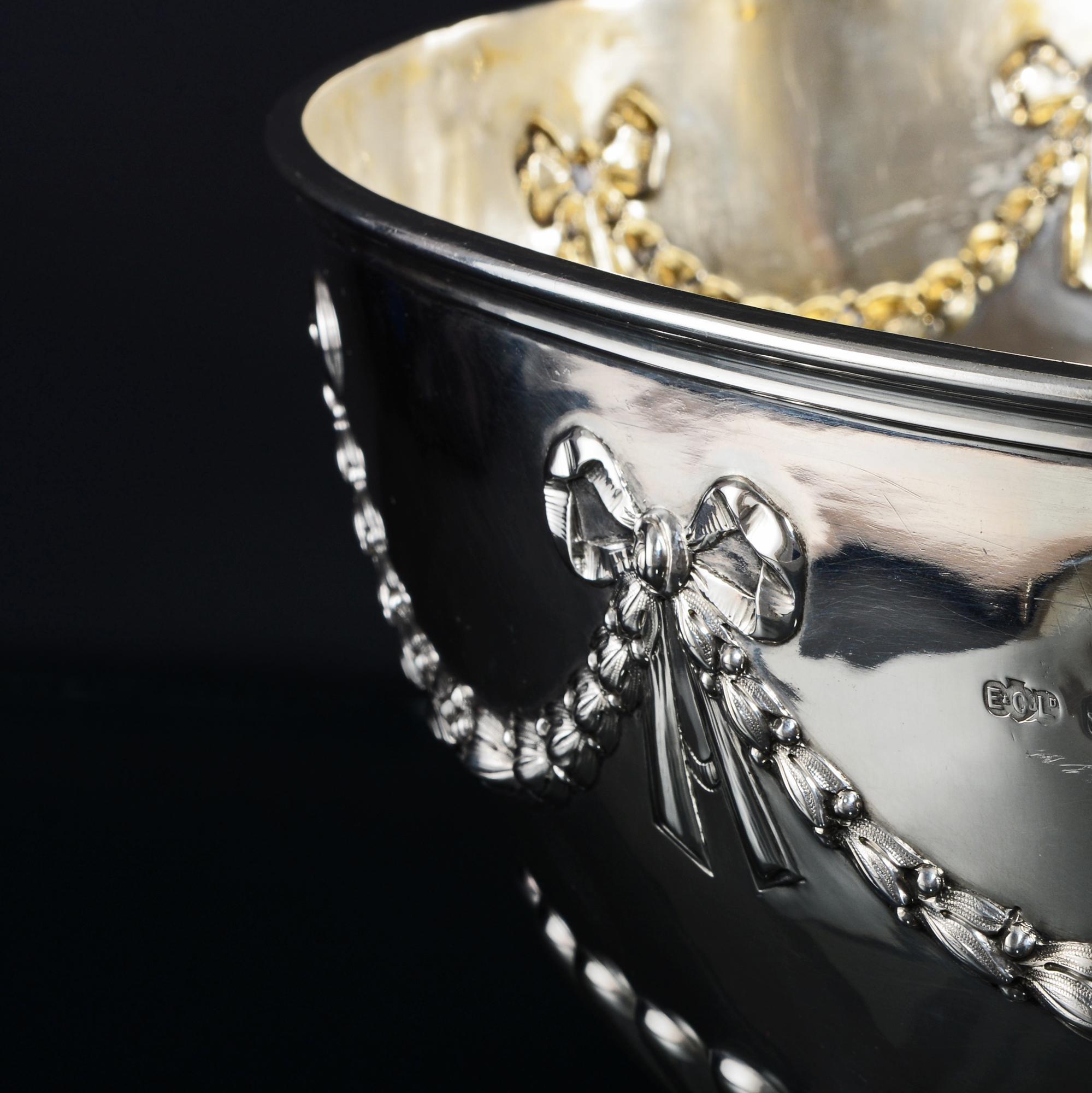This large and impressive antique silver punch bowl was made by Elkington & Co in 1893. It is substantially heavy, weighing almost 100 troy oz, and is classically decorated with half-fluting to the bottom half of the bowl with a band of harebell
