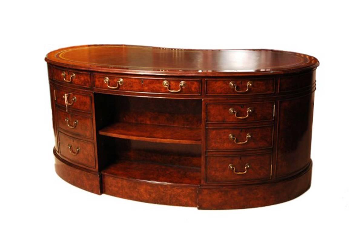 This is a grand Victorian style burr walnut kidney partner’s desk with a gold tooled leather writing surface and a modesty panel bookcase on the back, dating from the last quarter of the 20th century.

The desk is finished all round so it is free