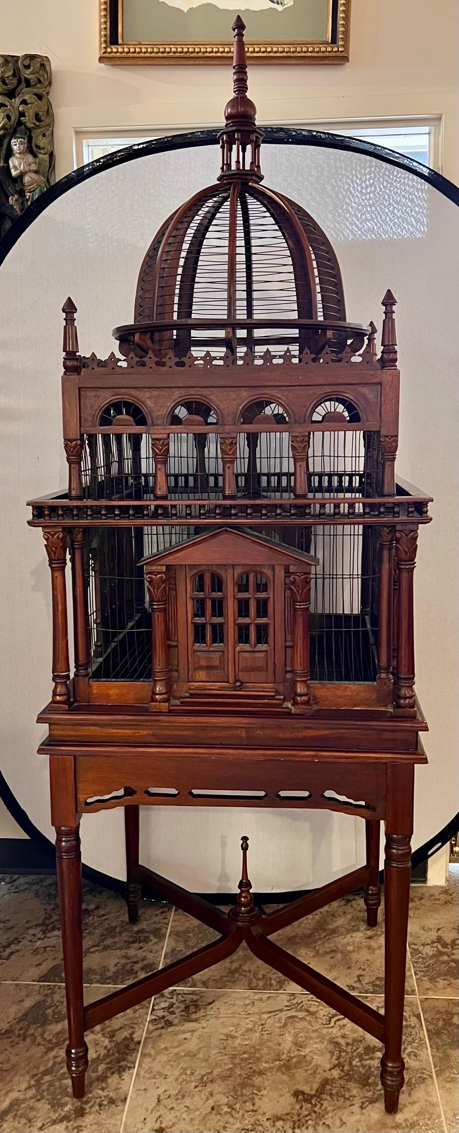 Stunning architectural birdcage made in the Victorian style. 
This exquisite piece is painstakingly hand crafted from smooth dark brown mahogany. A large eye catching central dome sits atop the piece.
The detail is quite amazing! 
Comes with