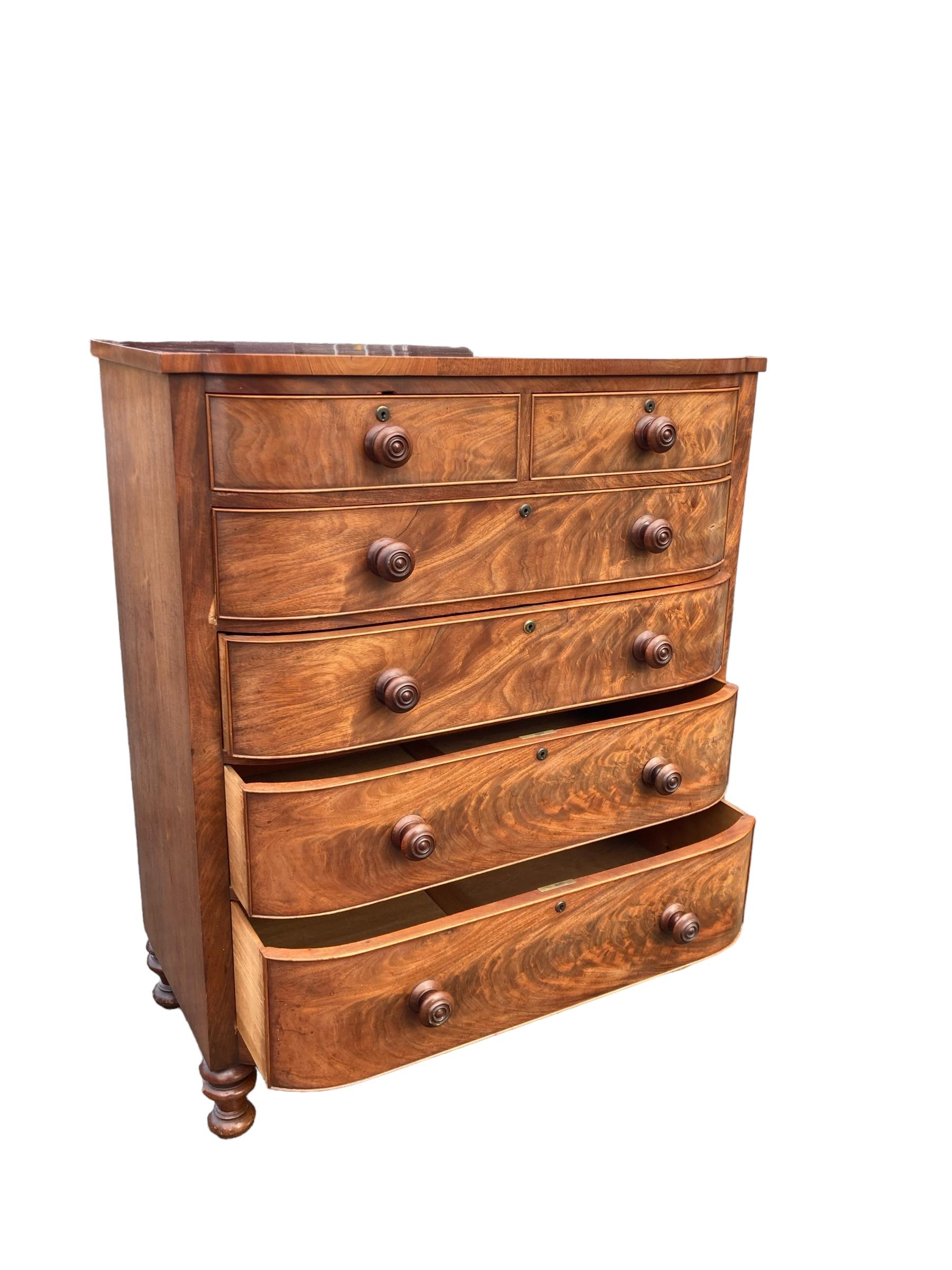 Large Victorian Two over Four Bow fronted Mahohany Chest Graduated drawers. Standing on turned legs, original handles.
This exquisite antique chest of drawers exudes elegance and charm, making it a perfect addition to any home decor. Crafted with