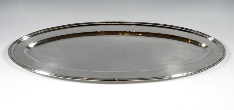 Oval shaped silver platter in a smooth, simple design with a profiled edge.

Branded by the Diana's head mark, the Viennese official hallmark 1872-1922 for 800 silver 

Manufacturer sign: 'FR' for Franz Rumwolf Senior,
Certified silversmith, k.
