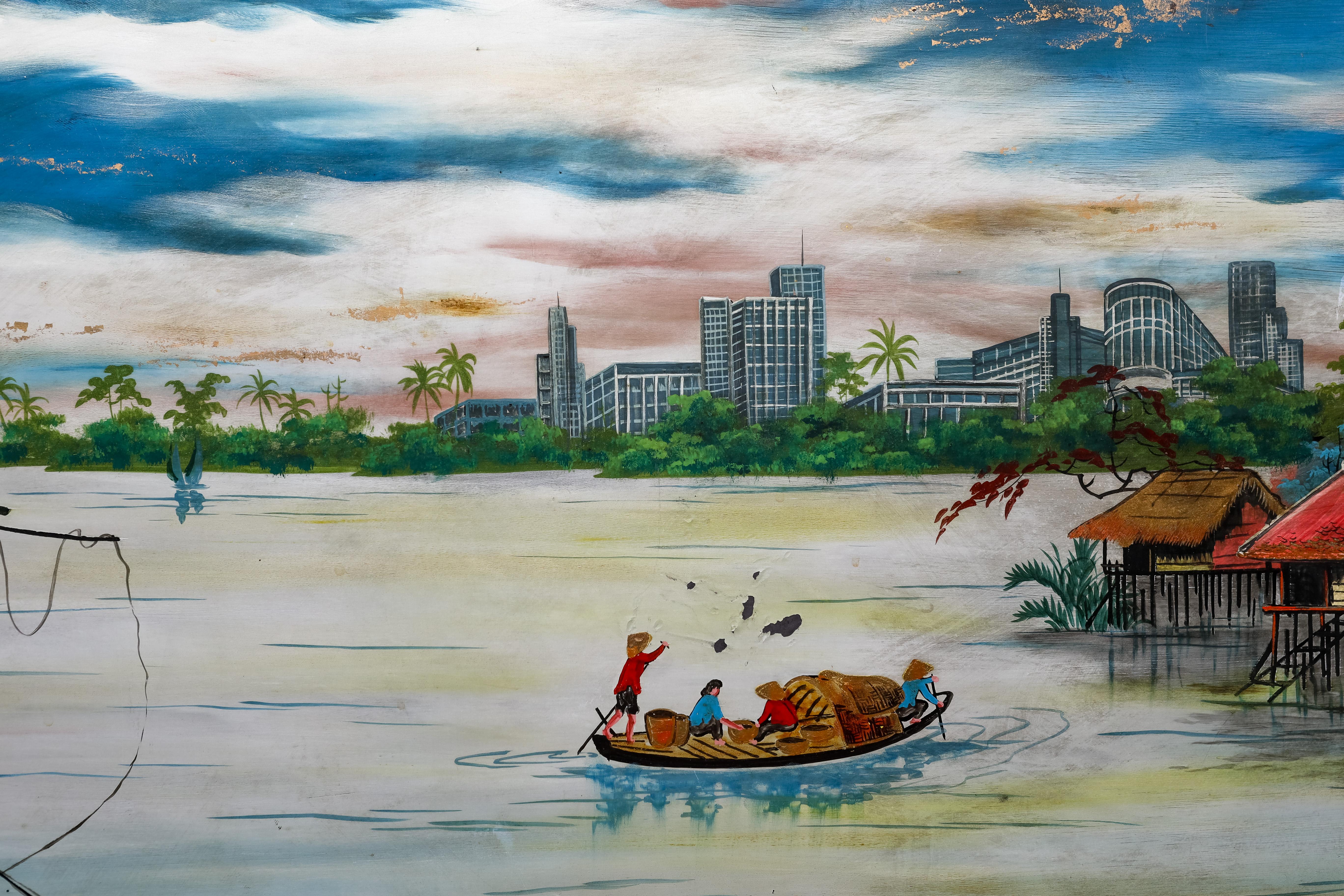 This lacquer depicts Vietnamese boats on a river with typical houses on stilts. On the back side there is a view of skyscrapers. This lacquer shows the contrast of two worlds. 