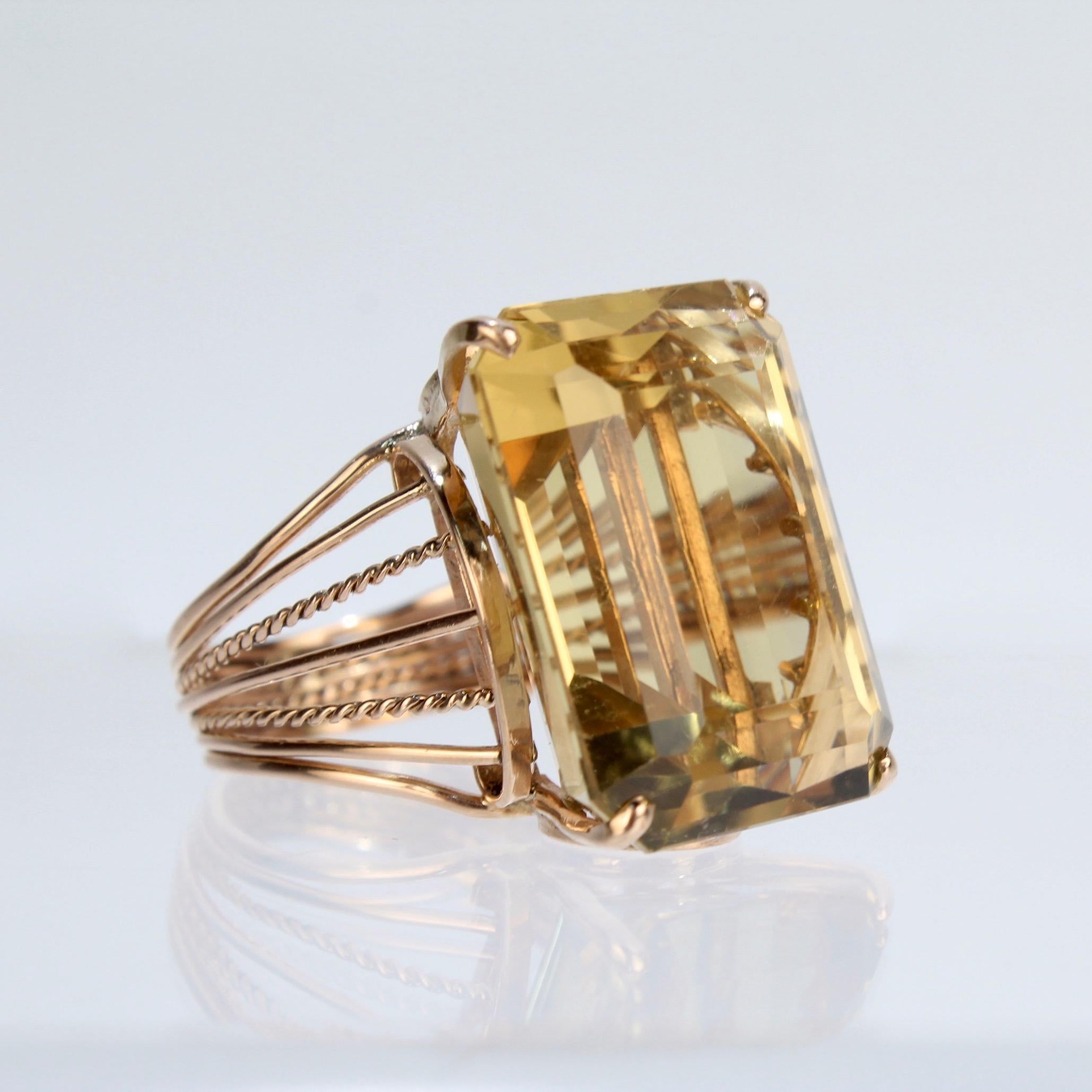 A great, large sized Citrine cocktail ring.

With a large emerald cut Citrine gemstone set in a 14k gold wire work setting. 

Simply a great statement ring and the perfect conversation starter!

Unmarked for fineness. Professionally tests at