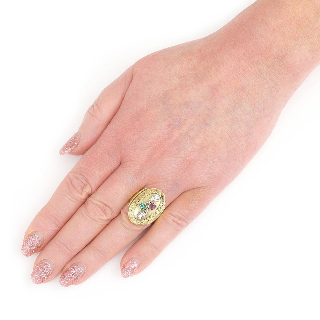 A funky vintage large oval 14ct yellow gold multi gemstone set ring, with a round pink tourmaline and a square cut green tourmaline, and four round brilliant cut diamonds. The bright diamonds have an estimated 0.25ct total weight. The oval setting