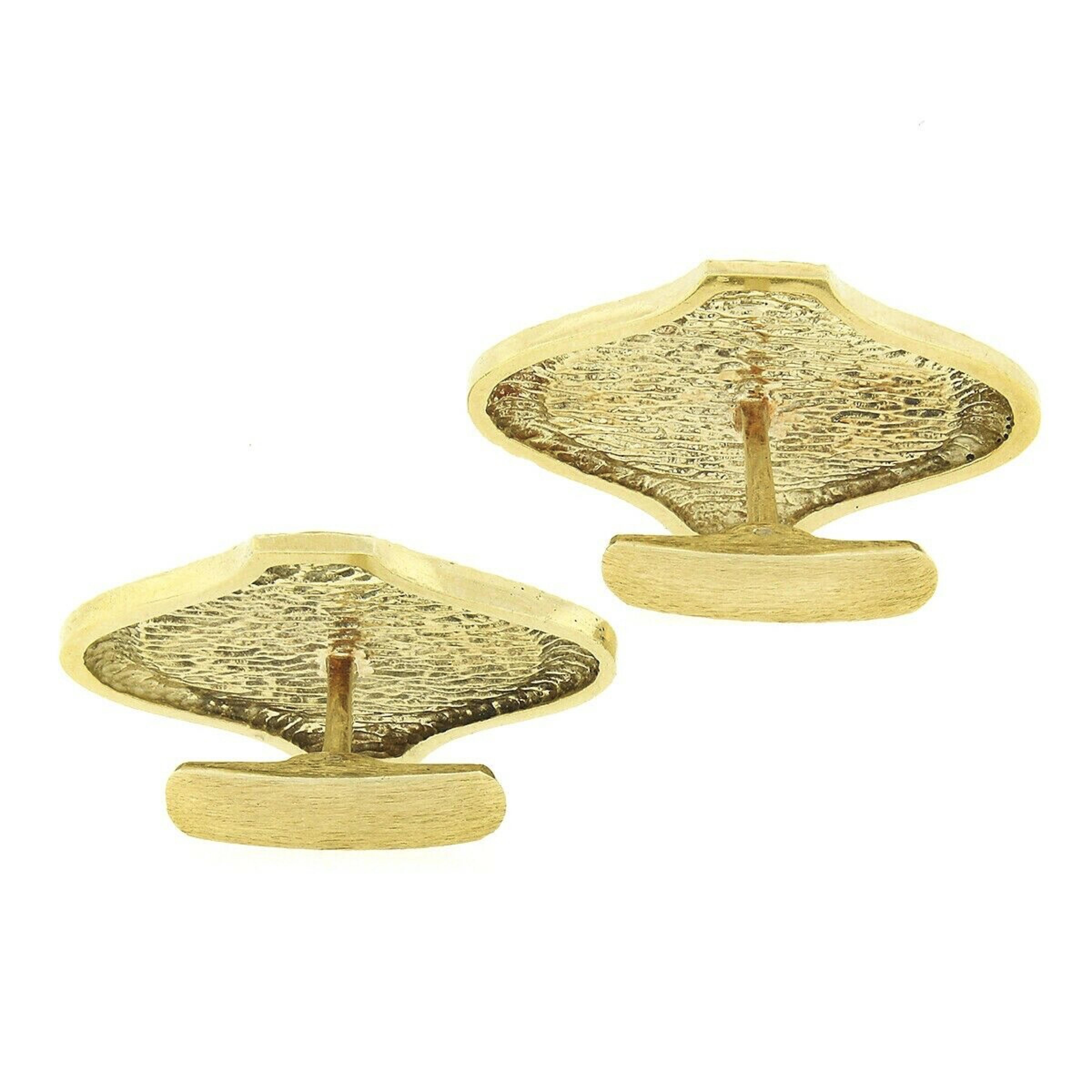 This fine pair of vintage cuff links is crafted in solid 14k yellow gold and features a large design with one link set with a natural tiger's eye stone and the other set with a natural lapis at their center. Each of these large polished stones is