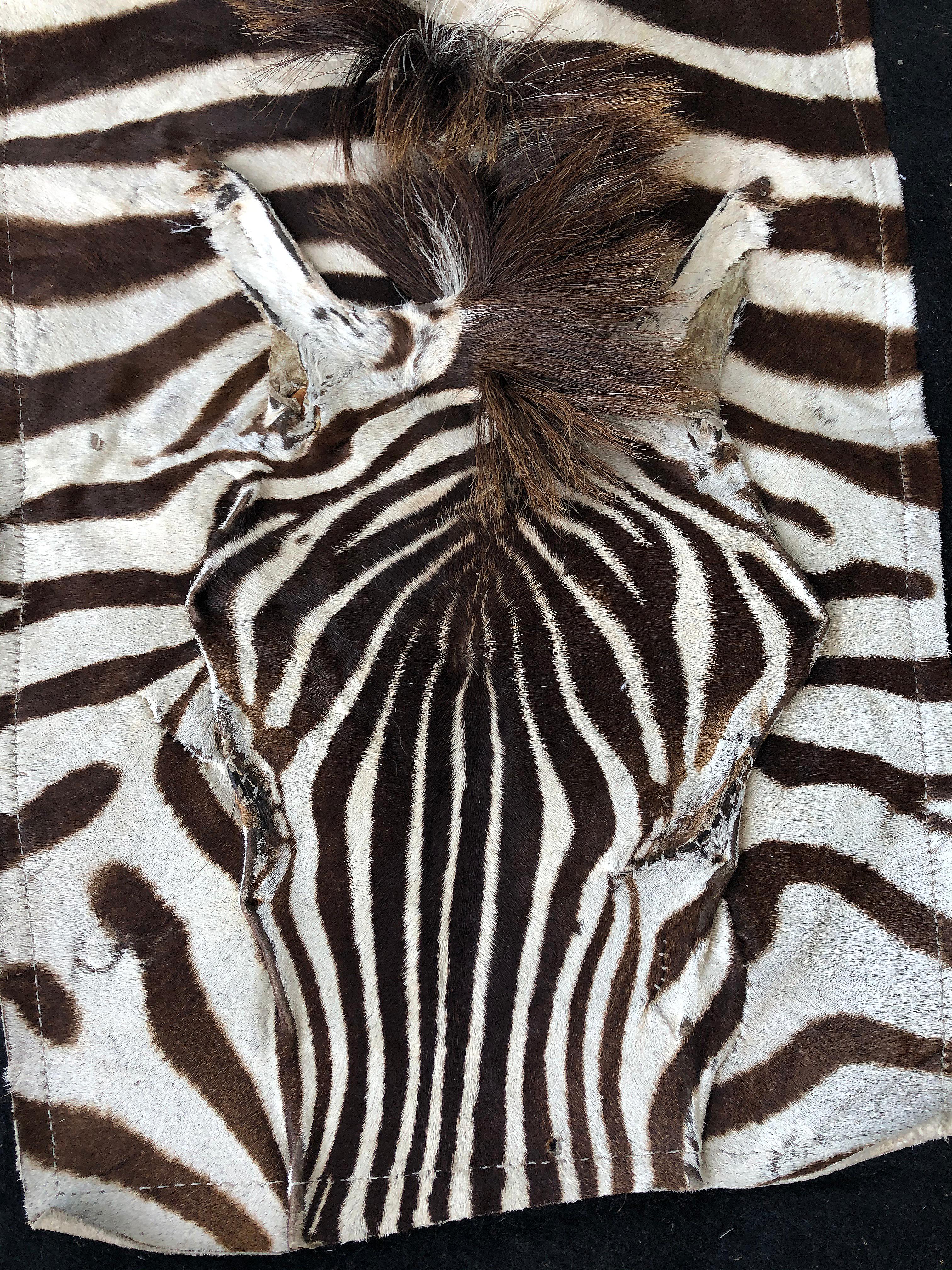 Large vintage African zebra hide taxidermy rug with felt backing

Offered for sale is a large striking African zebra hide taxidermy rug with a black felt backing. The rug retains the head and tail. It can be used on the floor or hung from the wall.