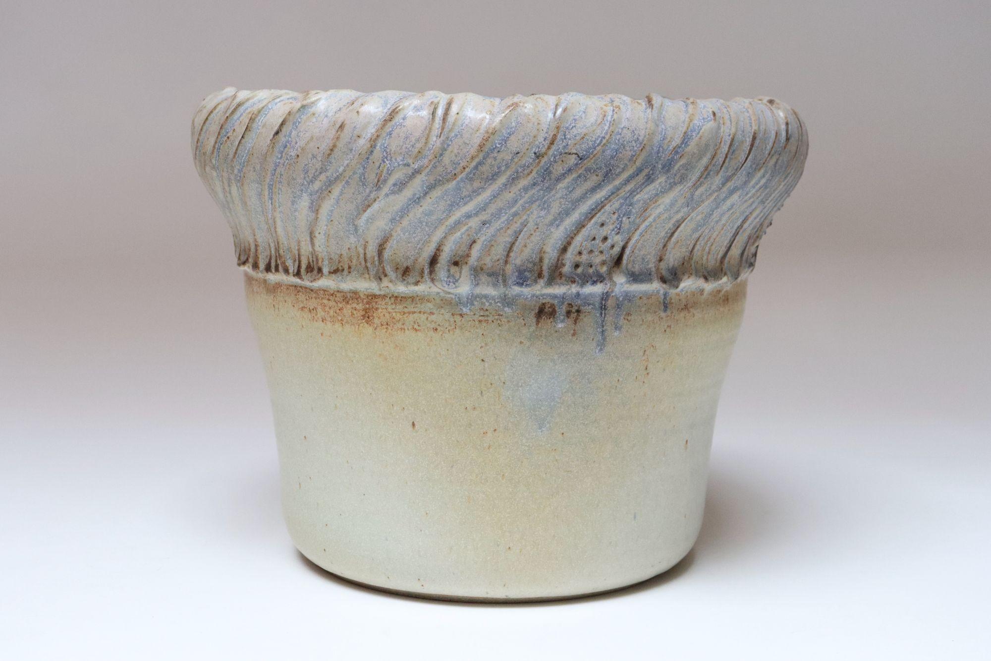 Macetero grande de cerámica de taller de la ceramista Deanna Nichols (nacida en 1942-2017, Misuri).
Licenciado en Bellas Artes por el Instituto de Arte de Kansas City (1965) y Máster en Bellas Artes por la Universidad de Postgrado Claremont de