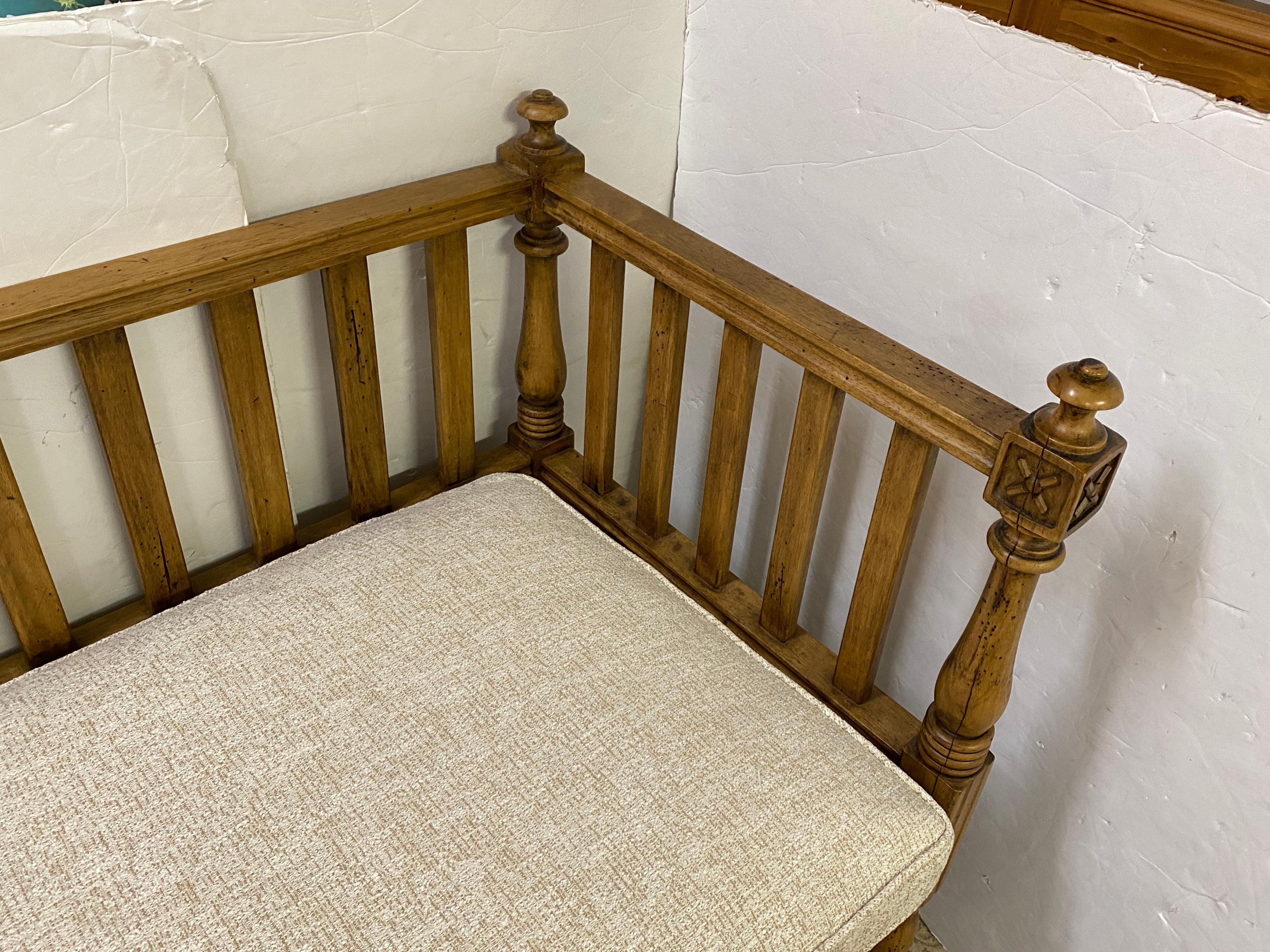 Large handsome oak bench in the Arts & Crafts style having squared off frame with back splats, turned legs, and 4 decorative finials.  Seat cushion has just been wrapped with new polyfill and cushion cover with a neutral  Crypton fabric, so it will