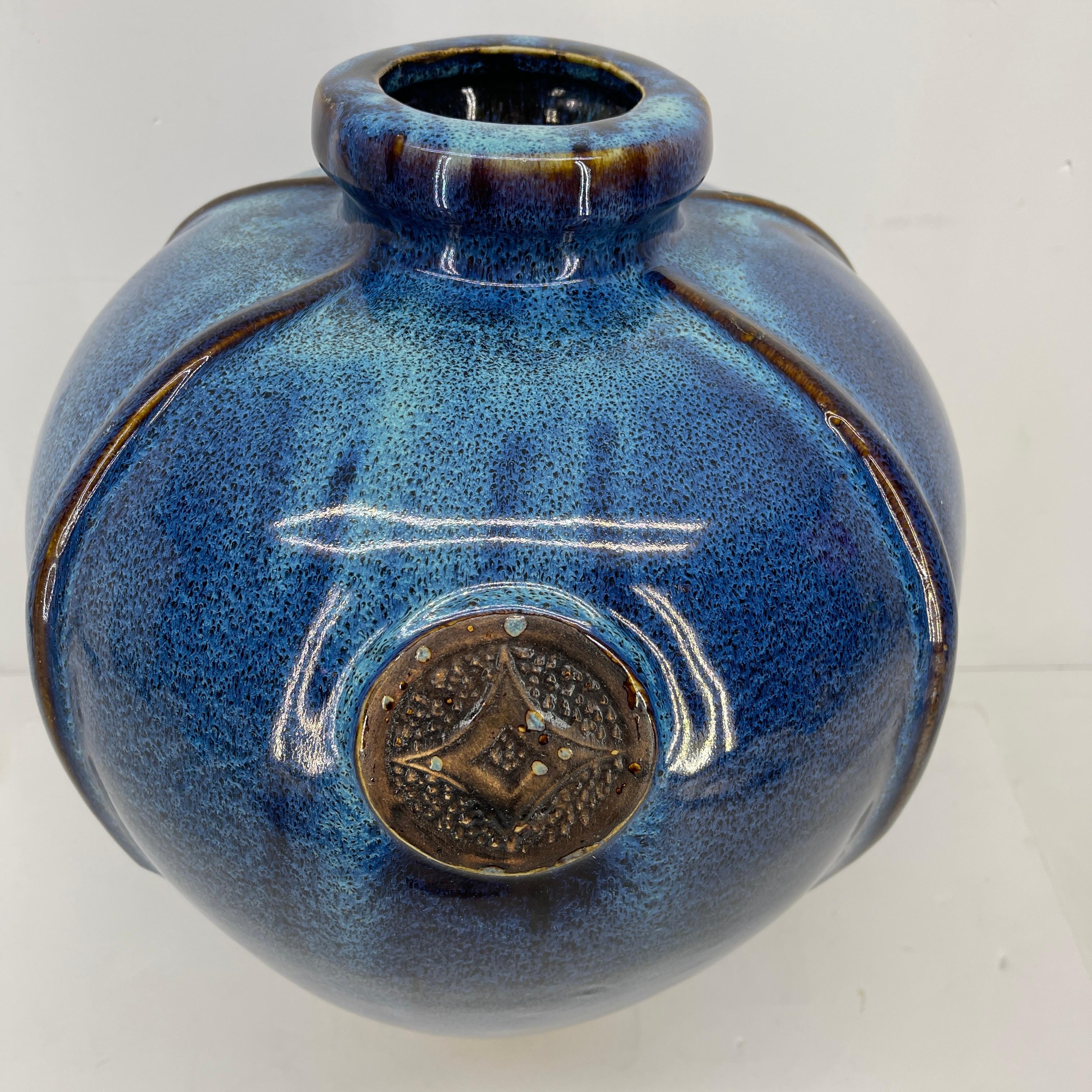 Large blue glazed ceramic vase, Mid-Century Modern.
This large hand crafted ceramic vase is an example of outstanding pottery work. The glazed is highly polished with shades of blue and teal. There is a large emblem of an elongated diamond pattern