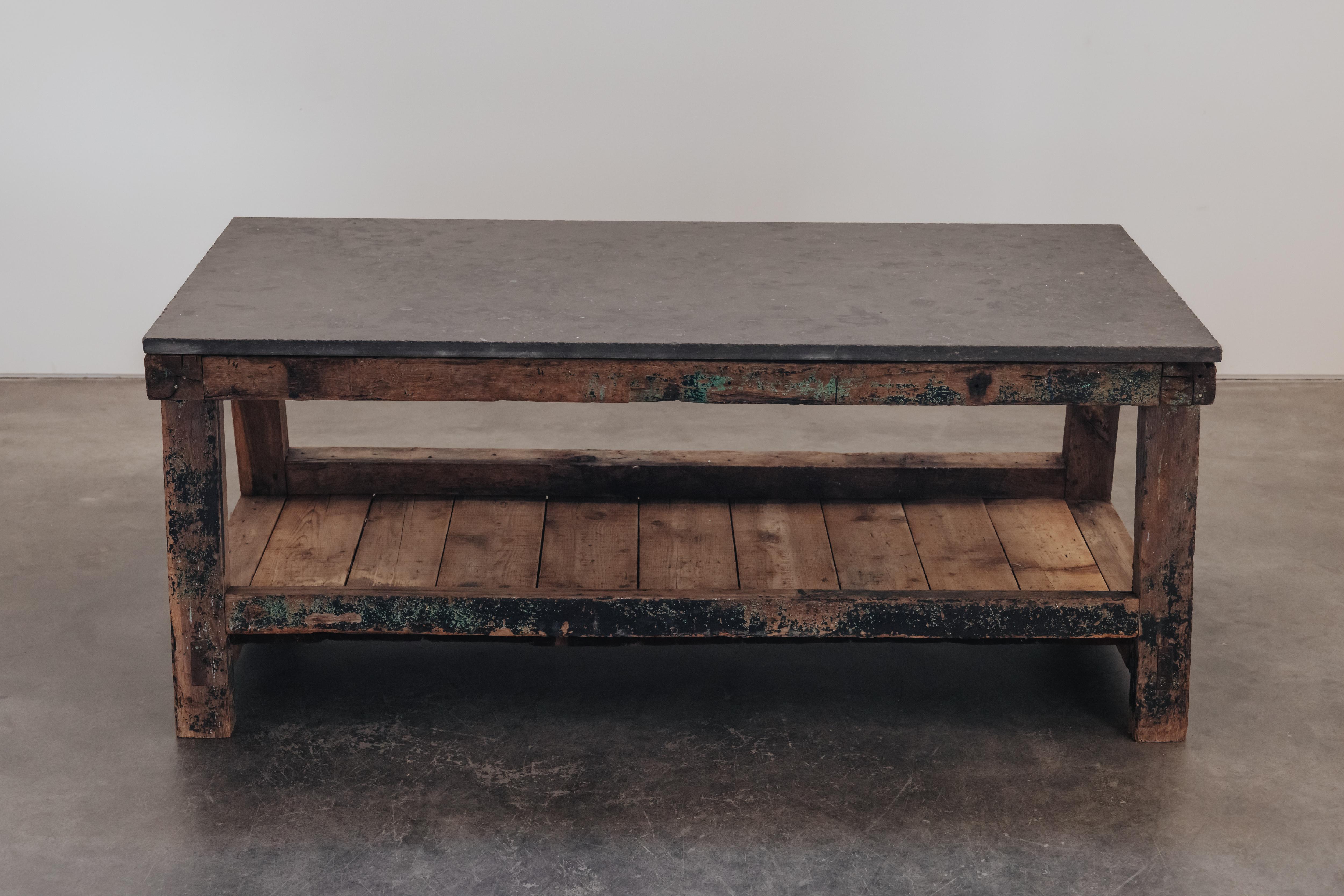 Grande tavolo da lavoro in pietra blu d'epoca proveniente dalla Francia, CIRCA 1940.  Piano in pietra blu massiccia su una base in pino massiccio.  Patina e usura fantastiche.