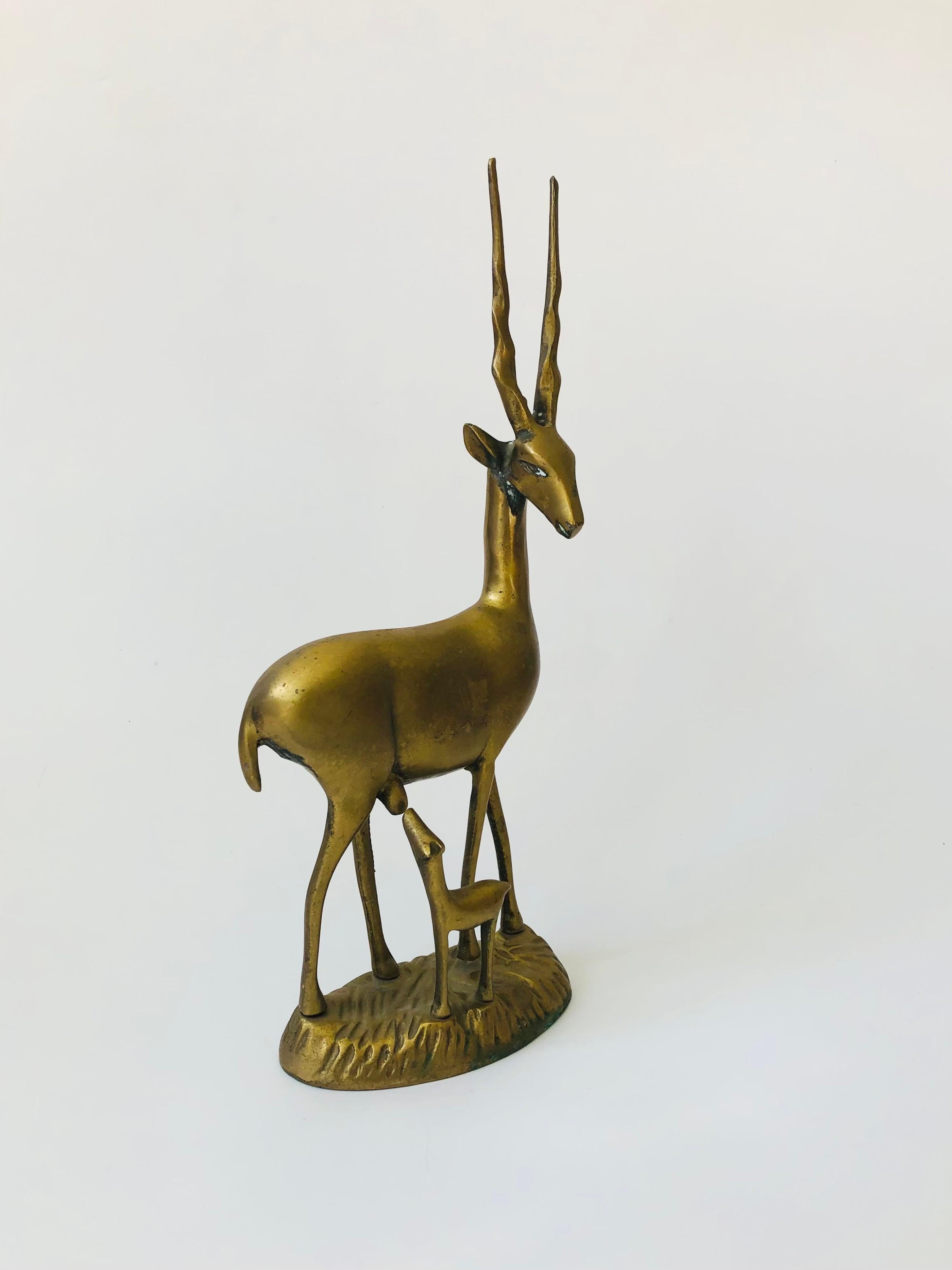 A large vintage brass gazelle with its baby. Beautiful gold patina and details formed into the brass.


