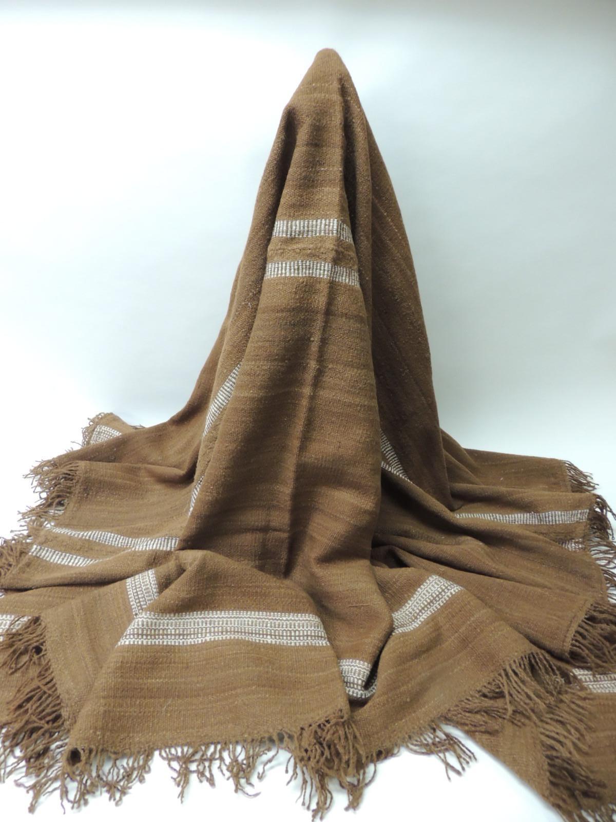 Vintage brown and white woven wool throw with hand-knotted fringes.
Large South American, thick woven cloth. Ideal on a table, sofa or chair. Also, on the food of a bed.
Size: 57.5 x 71.5.