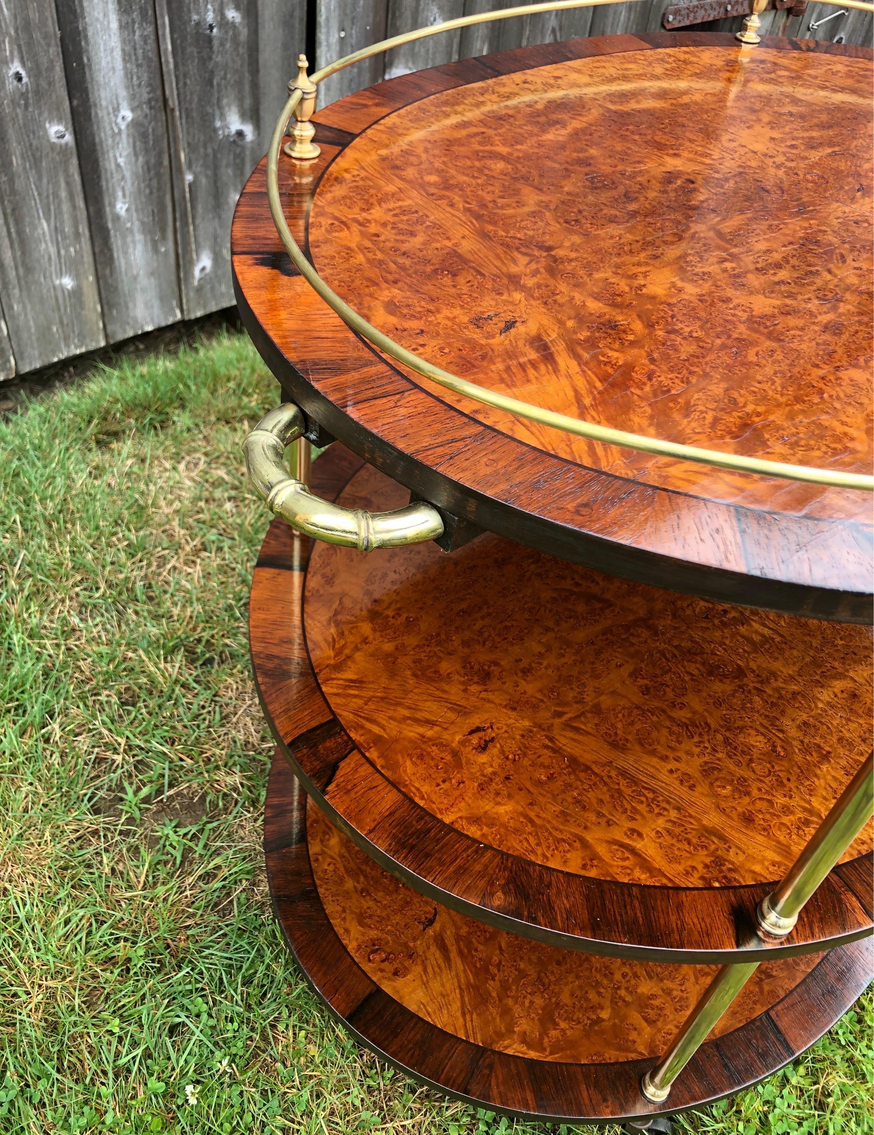 A very attractive Large Vintage Campaign Style Burled Elm Cross Banded with Rosewood Table or Bar Cart. The top shelf with a brass gallery, each separated with brass supports and raised on casters and faux bamboo brass handles. Campaign furniture