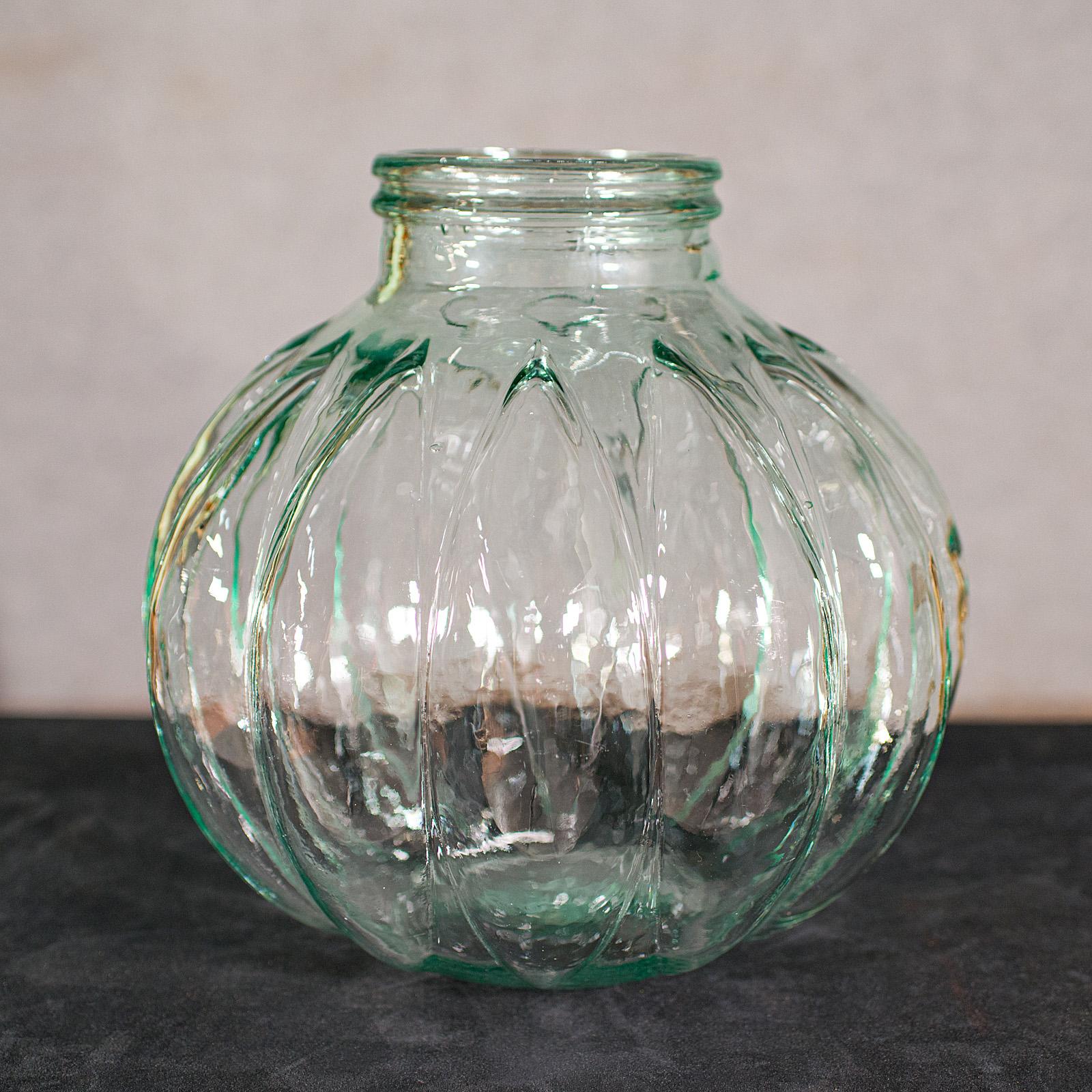 This is a large vintage carboy. An English, decorative glass storage jar, dating to the late 20th century, circa 1970.

Generously sized, with distinctive 'garlic clove' form
Displays a desirable aged patina throughout
Lightly green tinted glass