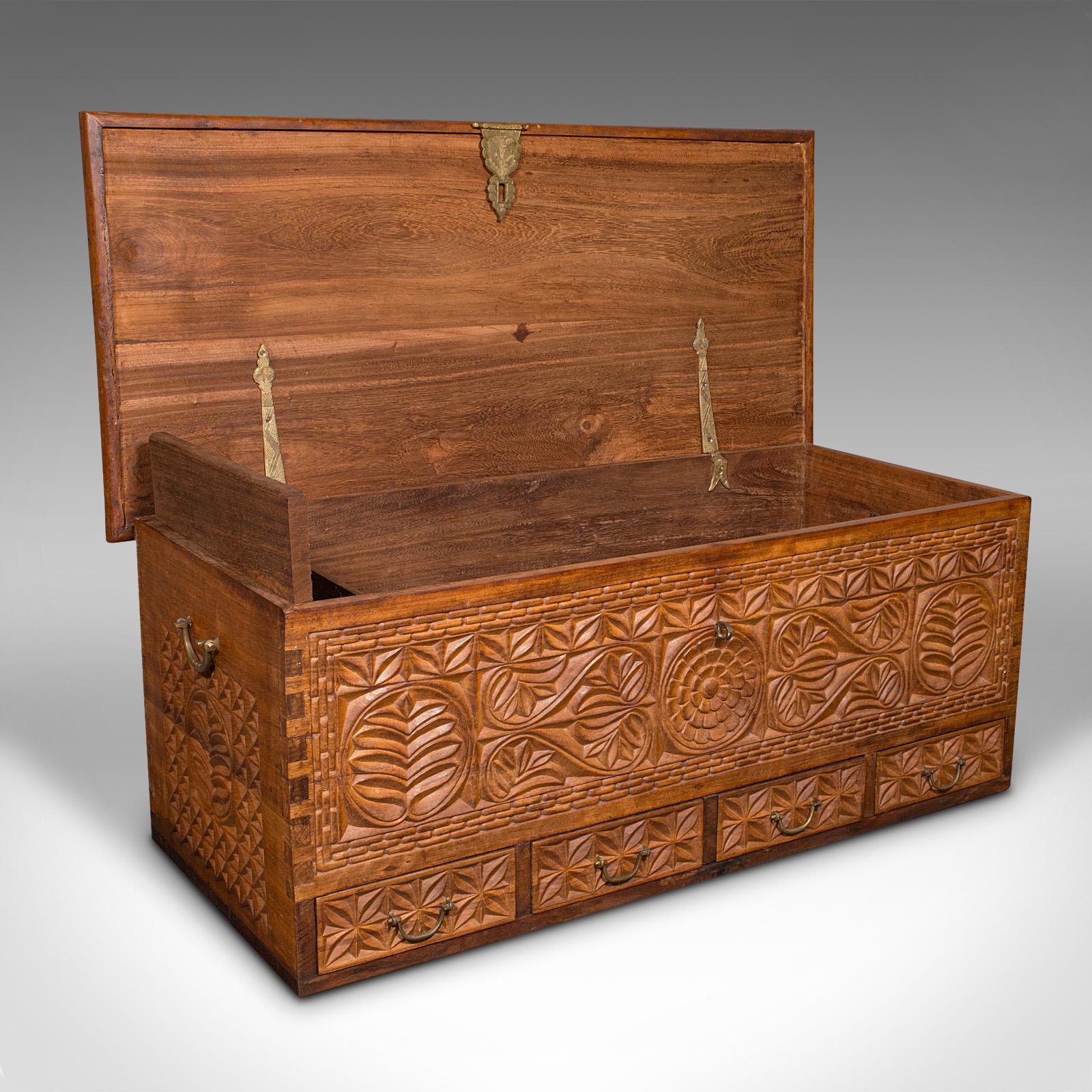 This is a large vintage carved chest. A Burmese, solid teak decorative trunk, dating to the Art Deco period, circa 1930.

Profusely decorated, with wonderfully substantial stocks throughout
Displays a desirable aged patina and in good order