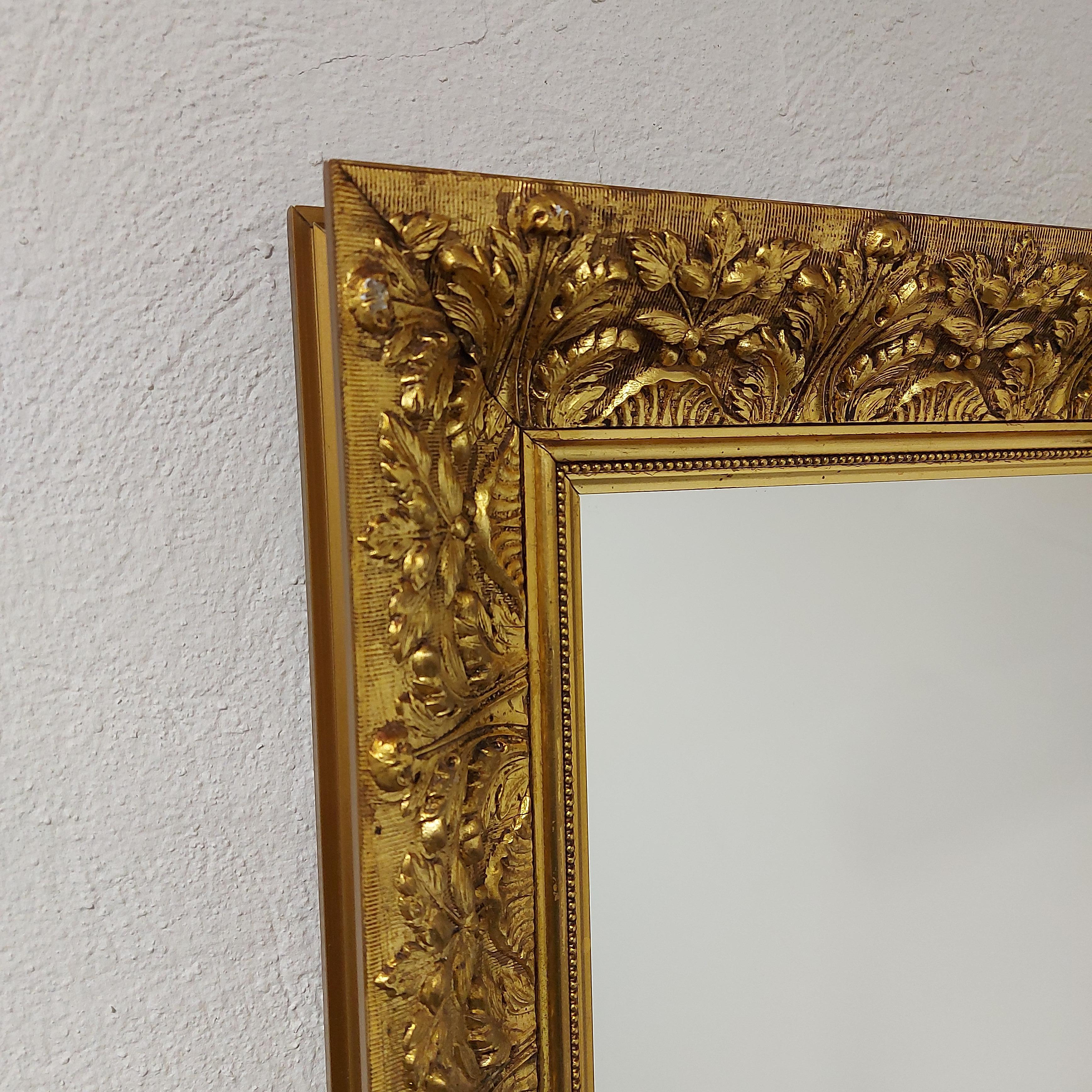 Good quality large gilt wall mirror, with a carved gilded frame from 1970, in excellent condition.  The frame is decorated with carvings in the style of early 19th century period.  The gilt wall mirror retains its original frame.  It is in large