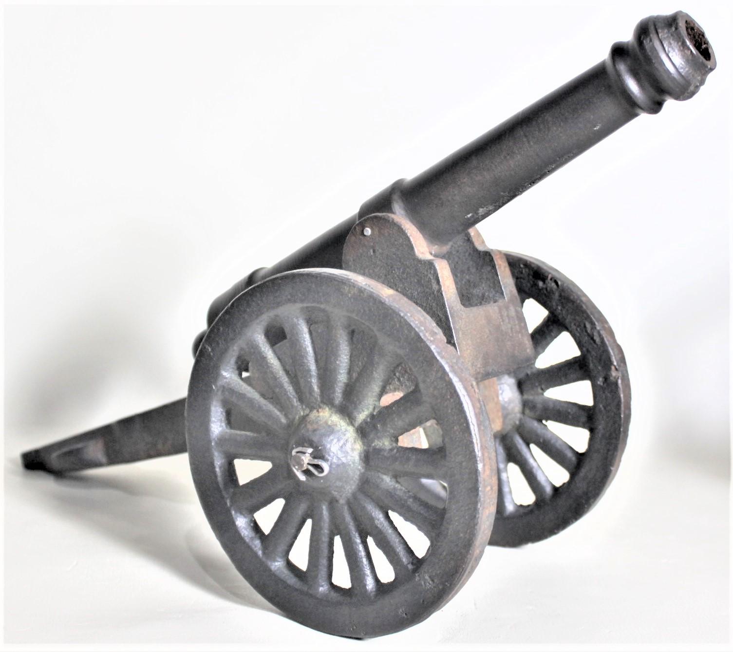 This large cast metal canon shows no maker's marks, but is presumed to have been made in the United States in circa 1965 in a Colonial Revival style. This model canon is composed of four parts; the frame, the barrel and two wheels. The wheels are