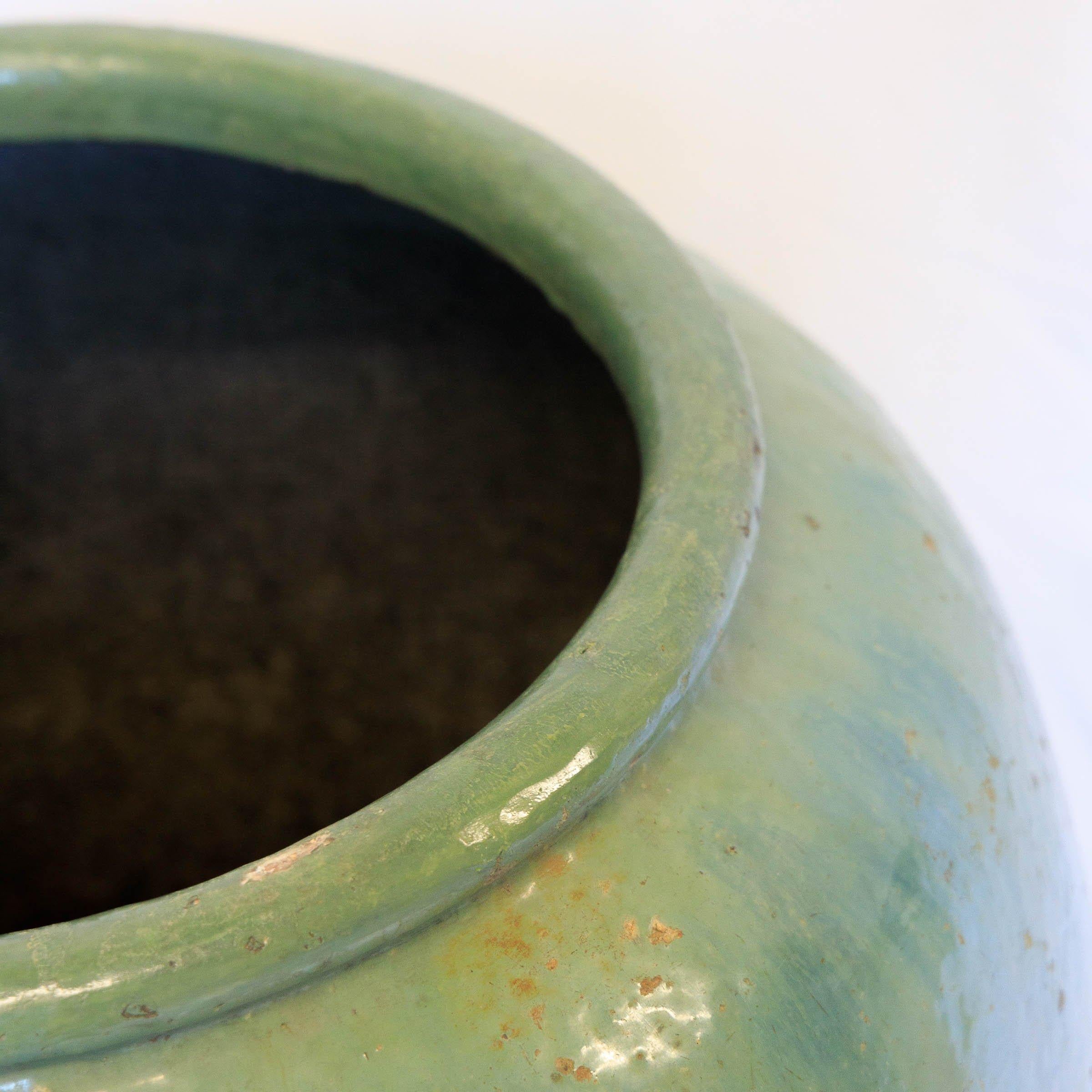 Vaso d'acqua vietnamita smaltato celadon vintage di grandi dimensioni con un'elegante forma a urna. Lo smalto verde giada, con la sua sottile screpolatura, emana una raffinatezza senza tempo. Versatile per l'uso all'interno o all'esterno, fa un
