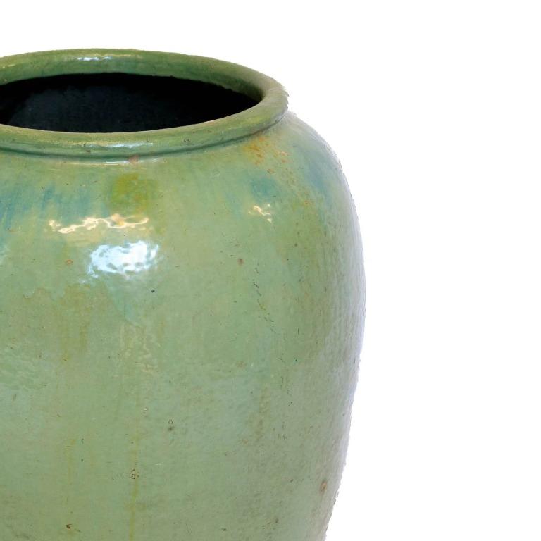 Oversized vintage celadon-glazed Vietnamese water jar vessel with elegant urn shape. The jade-green glaze, with its subtle crackle, exudes timeless sophistication. Versatile for indoor or outdoor use, it makes a striking statement as a planter or