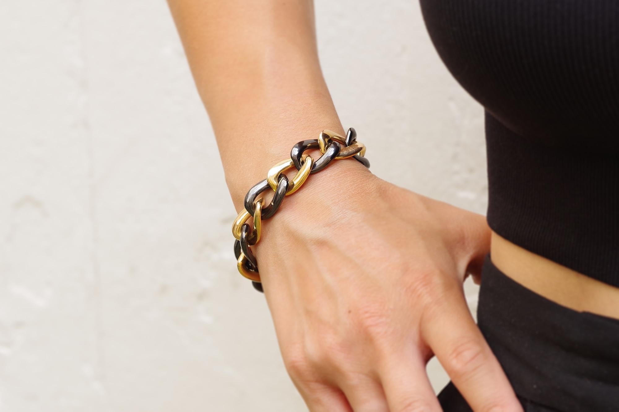 Large vintage ceramic bracelet in 18 karats gold bracelet. Bracelet with large links of yellow gold and ceramic, creating a beautiful contrast between the color of the two materials. The clasp is concealed in an invisible gold ring. Second-hand