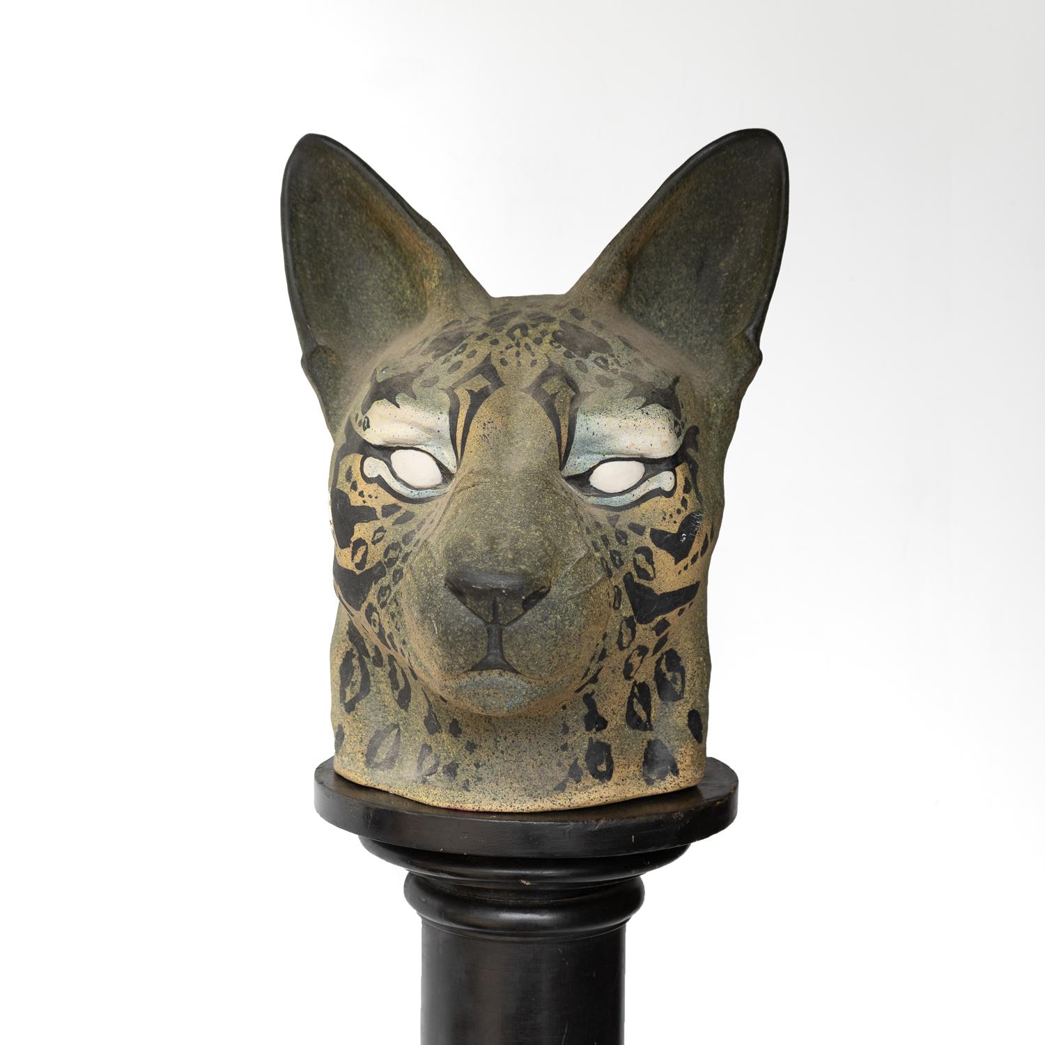 LARGE VINTAGE CERAMIC SCI-FI INSPIRED CAT HEAD SCULPTURE, 1970S

Part science fiction, part leopard, part ancient Egyptian god this sculpture depicts a powerful feline with green and yellow skin tones, blue eye shadow and piercing white eyes, and