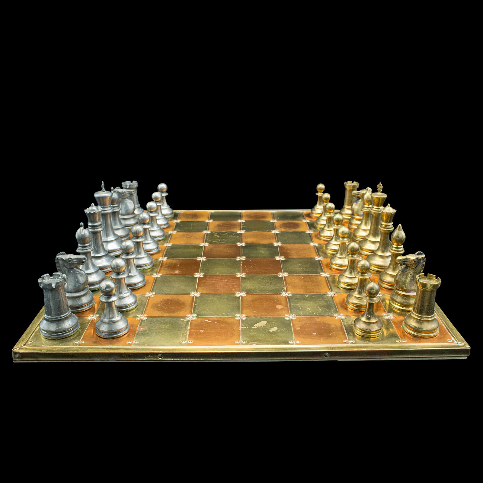 This is a large vintage chess board. An English, brass, copper and pewter brass gaming set, dating to the late 20th century, circa 1980.

Distinctive shimmering appearance to this weighted chess set
Displaying a desirable aged patina