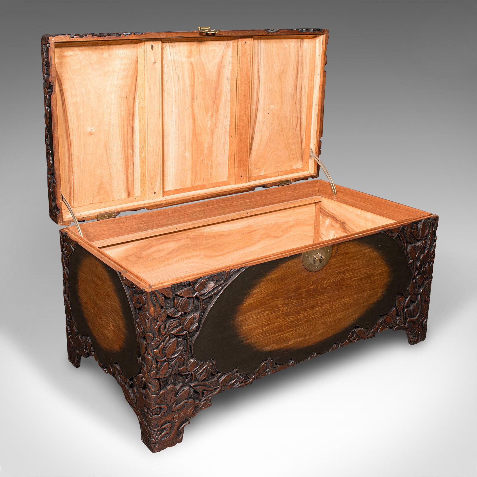 This is a distinguished Chinese camphorwood linen trunk, dating to the Art Deco period, circa 1930. 

Beautifully adorned with leaf and foliate carvings, this generously sized blanket chest offers both practical storage and exquisite craftsmanship.