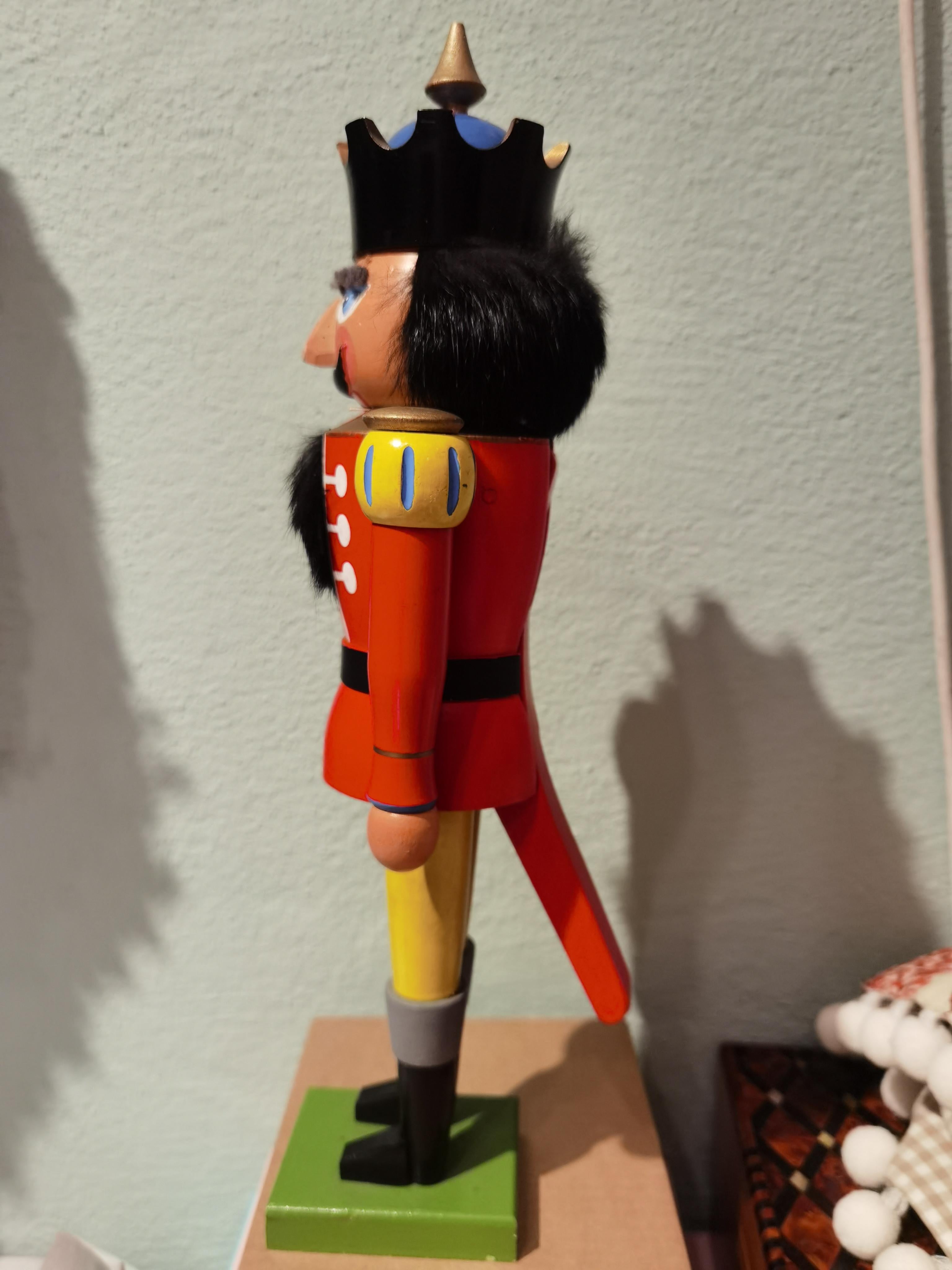 Large wooden nutcracker figure from the Erzgebirge. The region Erzgebirge formerly Eastern Germany is famous for this special kind of nutcrackers, where intricate carving has been their home. Completely hand-painted in red and yellow colors and