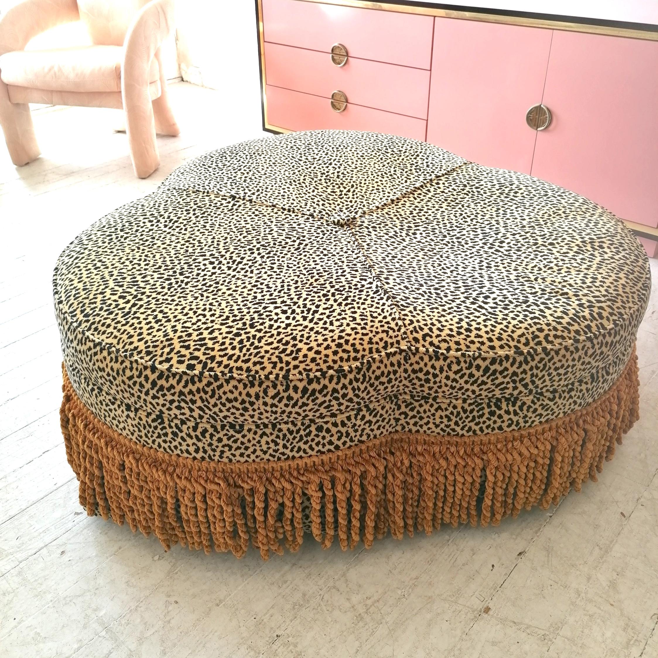 Gorgeous vintage American cloverleaf-shaped leopard pouffe / ottoman. The top part is sprung; stands on wooden legs (which are covered by a leopard kick pleat skirt) with brass ball Shepherd casters. Upholstered in its original thick, luxurious