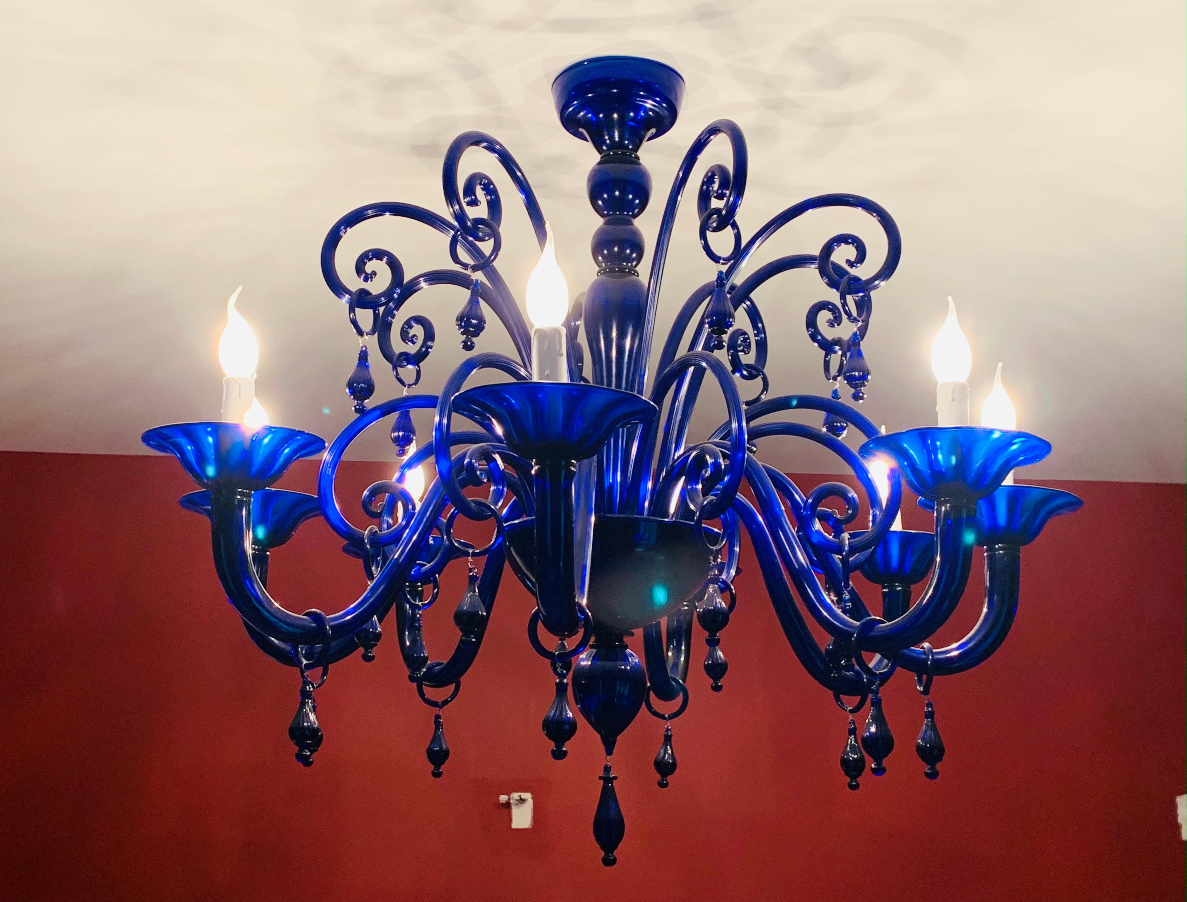 A stunning, cobalt blue, large, Italian, vintage, hand blown, Murano glass chandelier featuring unusual curled and whimsical glass scrolls. The chandelier is all the more striking because of its colour and the decorative droplets which hang from