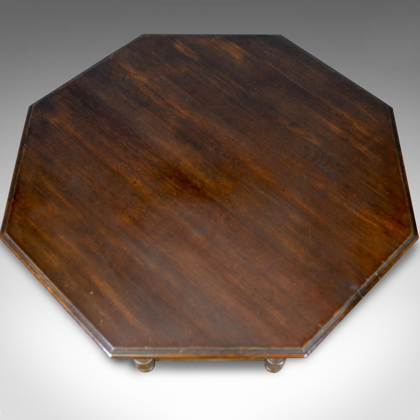 This is a large vintage coffee table. An English oak, octagonal low table dating to the late 20th century.

Large, solid oak coffee table
Octagonal top with edge molding 
Rich, dark wax polished finish.

Deep apron features a pair of hidden