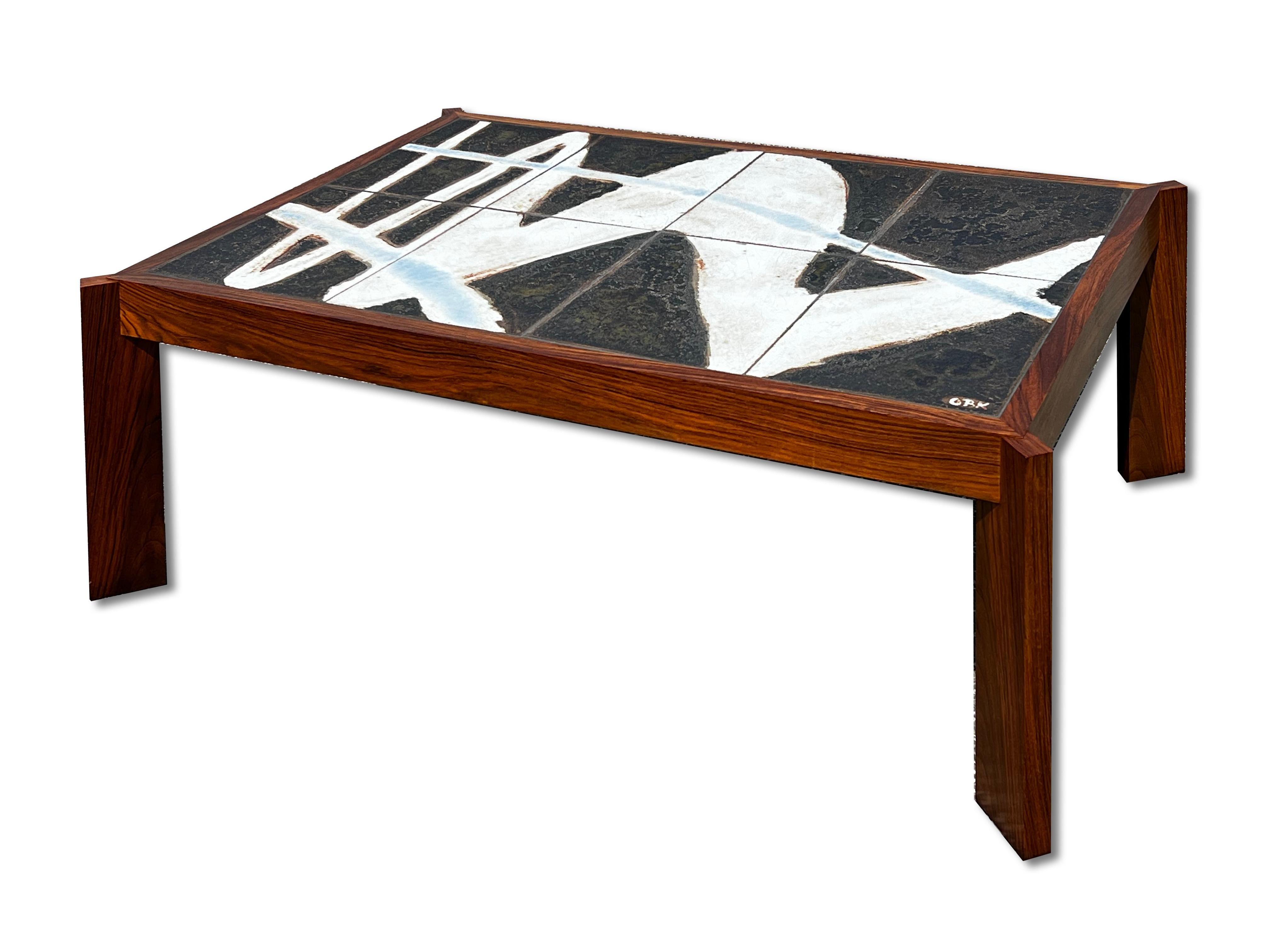 Large coffee table in massiv wood with a ceramic top created and signed by Ole Bjørn Krüger (1929-2007) in the sixties. The tabletop is composed of eight large tiles forming an abstract pattern in shades of white and light blue on a dark background.
